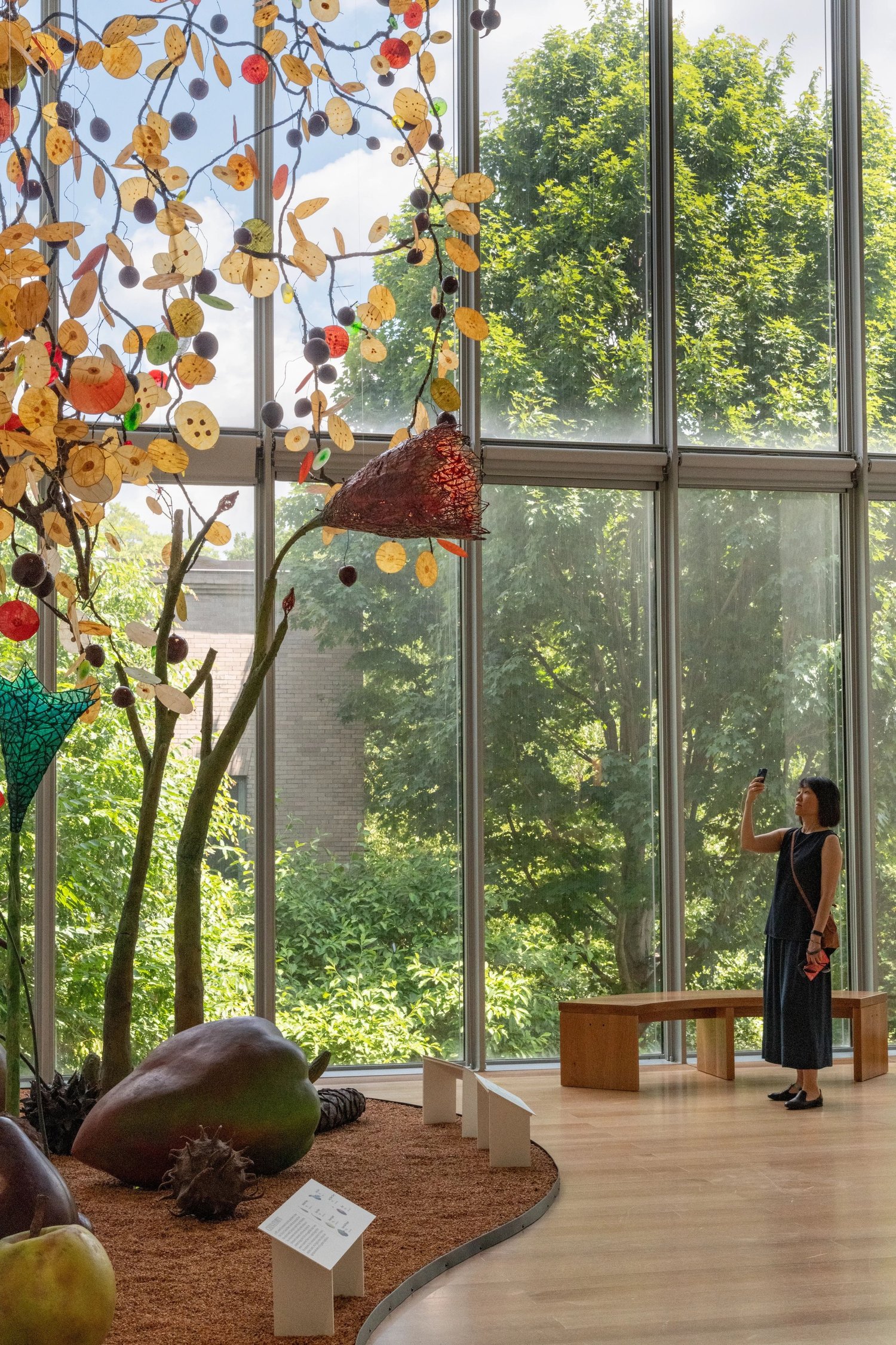 A visitor among Ming Fay sculptures, garden light behind