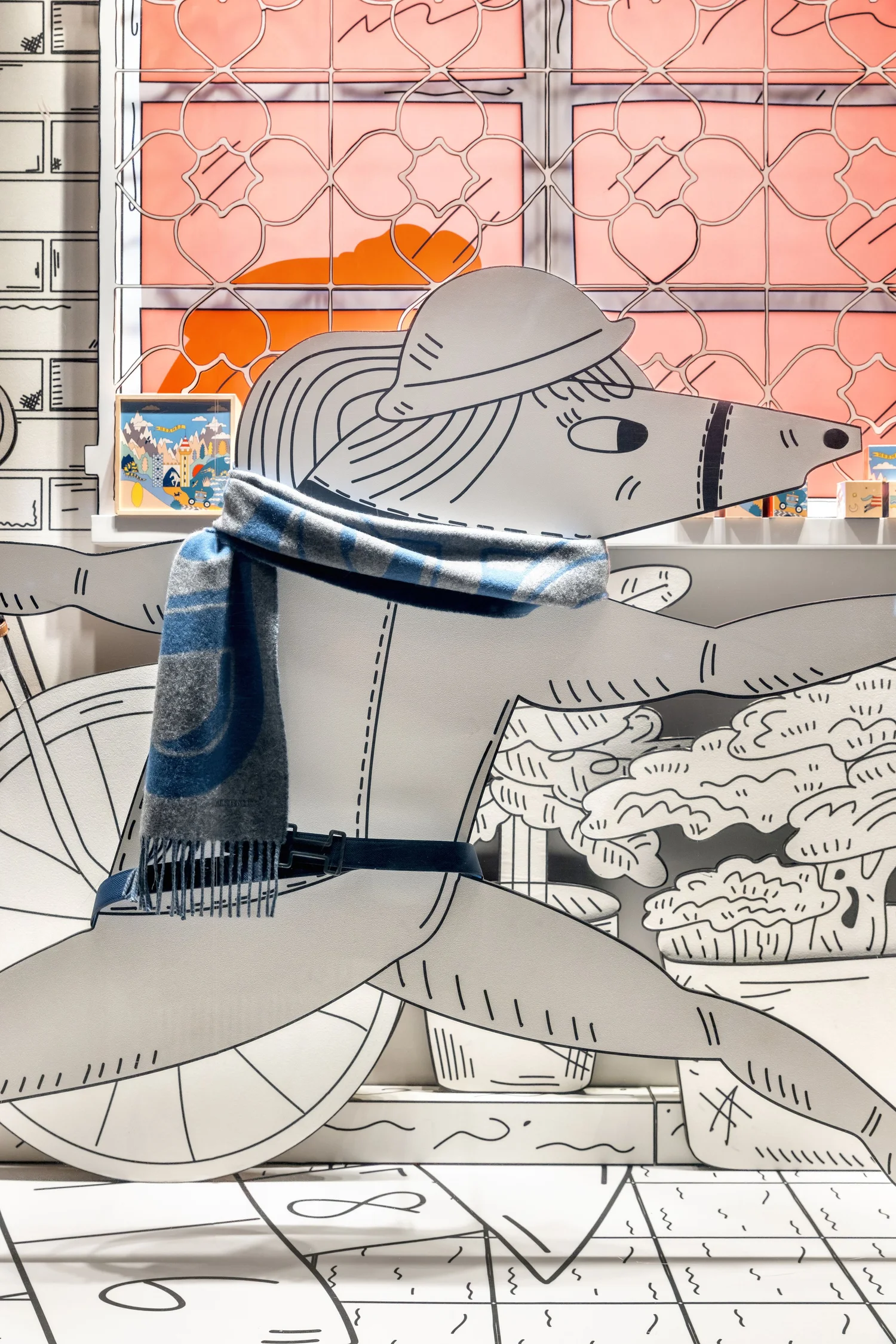 Hermès window detail: silk scarf over a hand-drawn scene