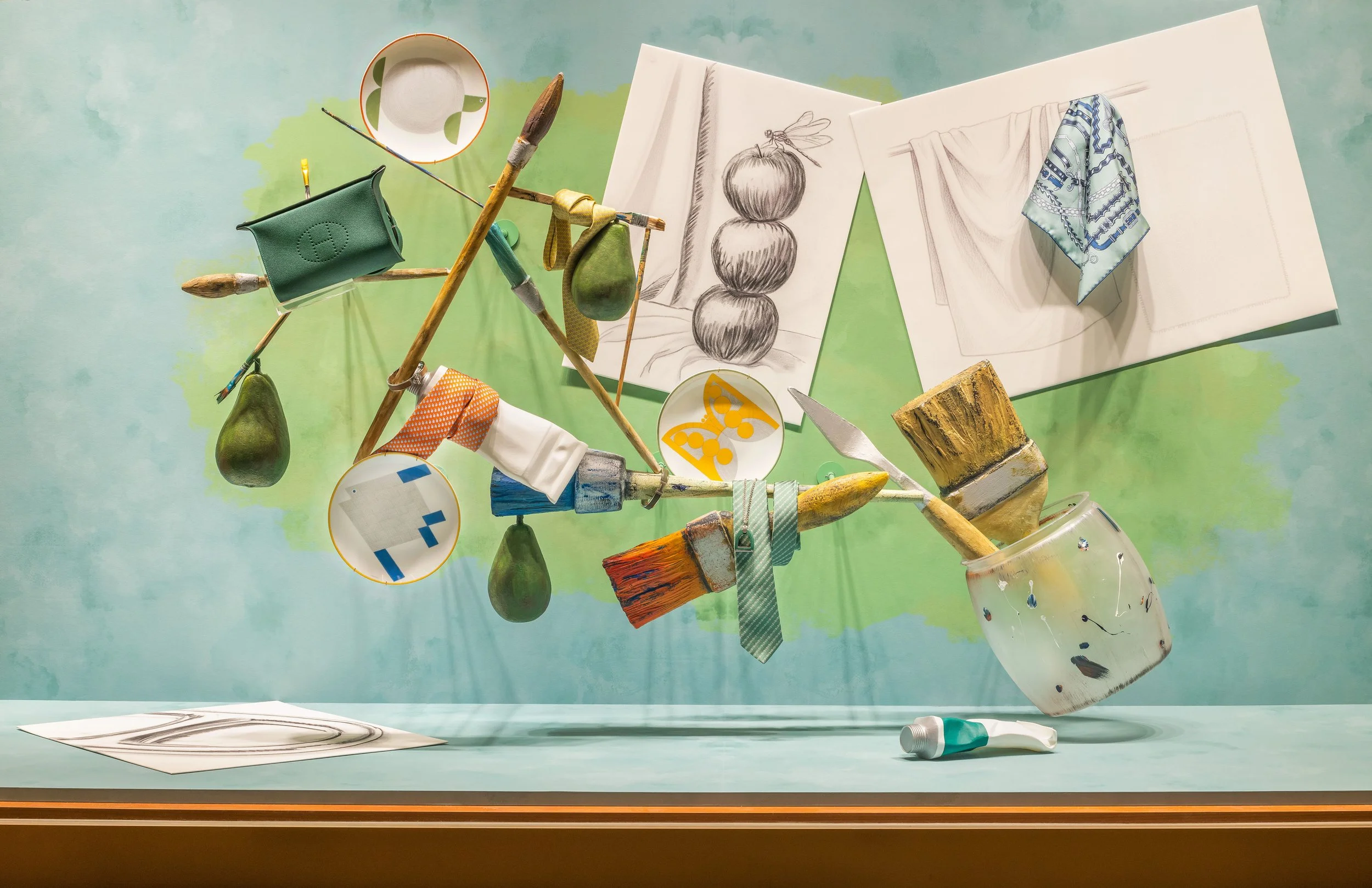 Hermès window by AMCP Studio: brushes, scarves and sketches suspended in an artist studio