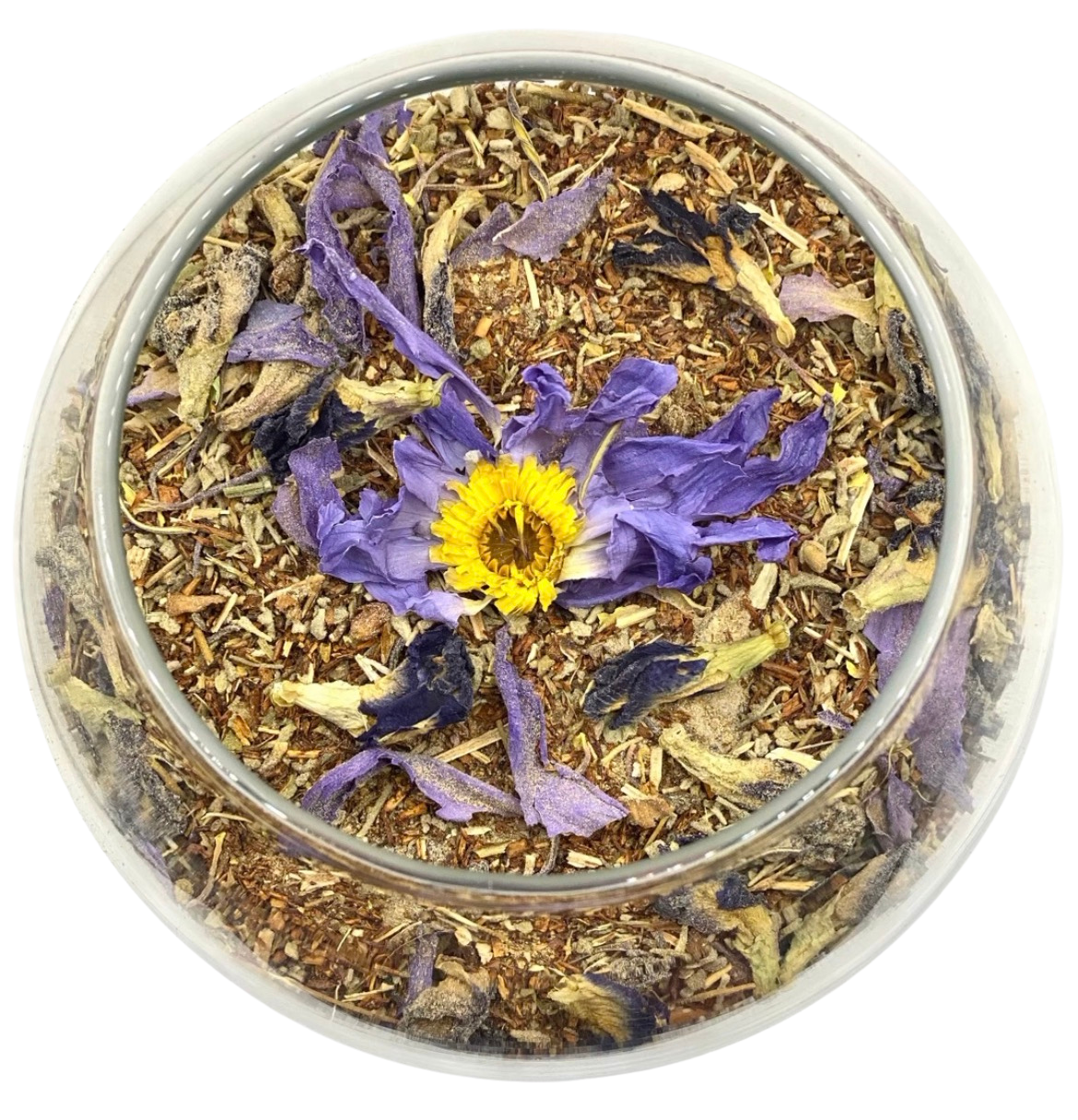 A clear glass container filled with dried purple flowers, herbs, and spices, with a single yellow and purple flower on top.