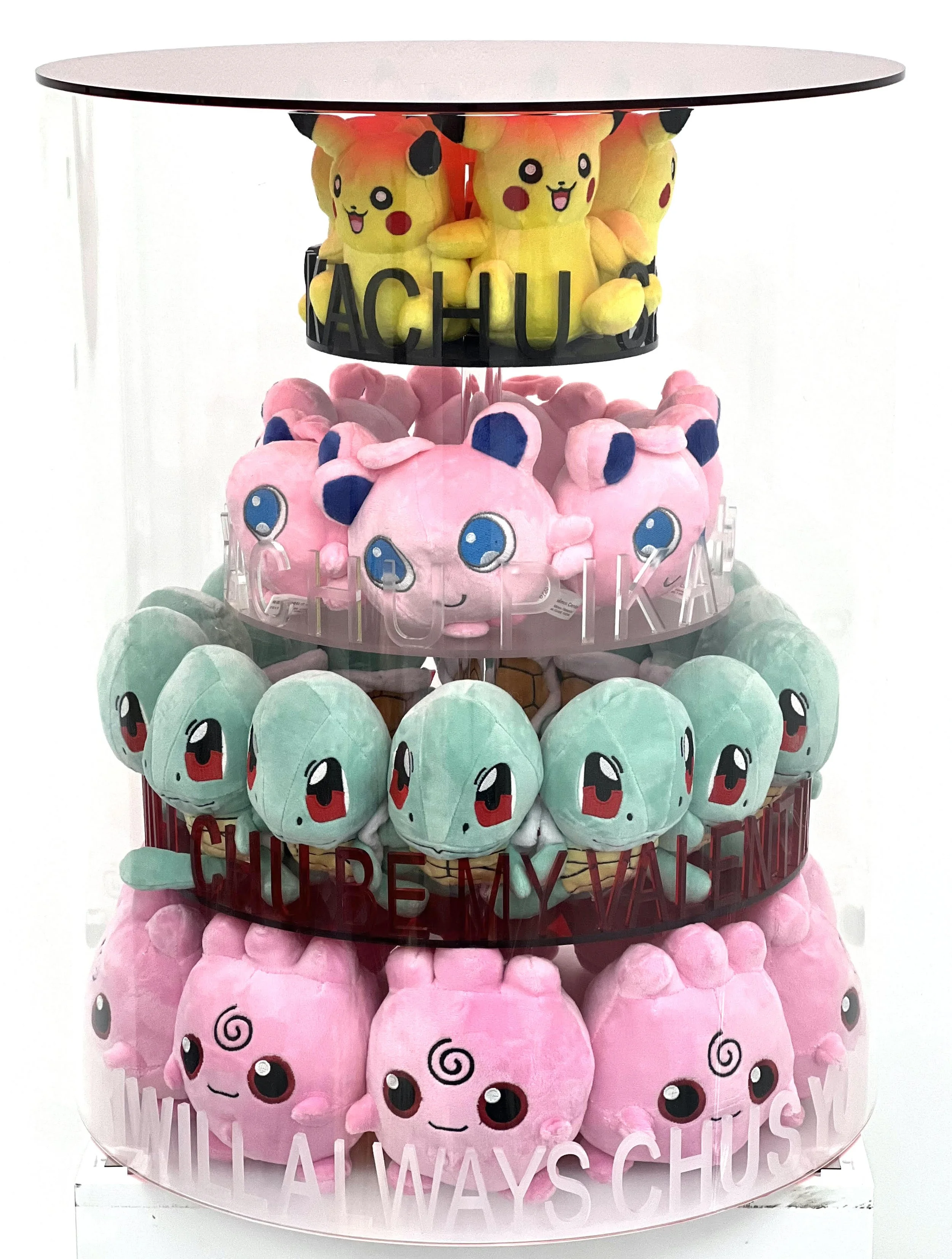 A multi-tiered display of Pikachu, Jigglypuff, Squirtle, and Clefairy plush toys arranged on circular shelves with humorous phrases