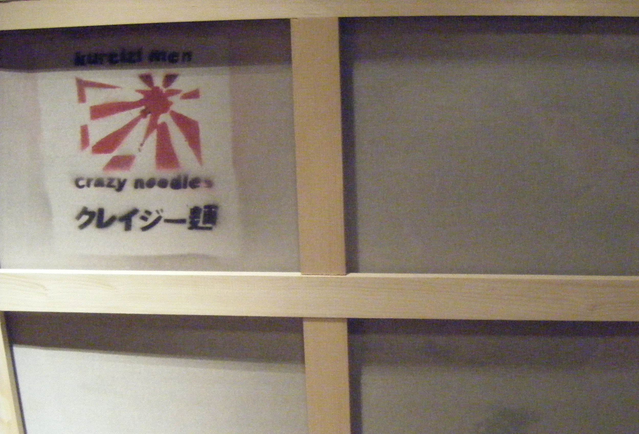 Shelf with a Japanese restaurant menu featuring a logo with a red windmill and the text 'Crazy Noodles' and Japanese characters.