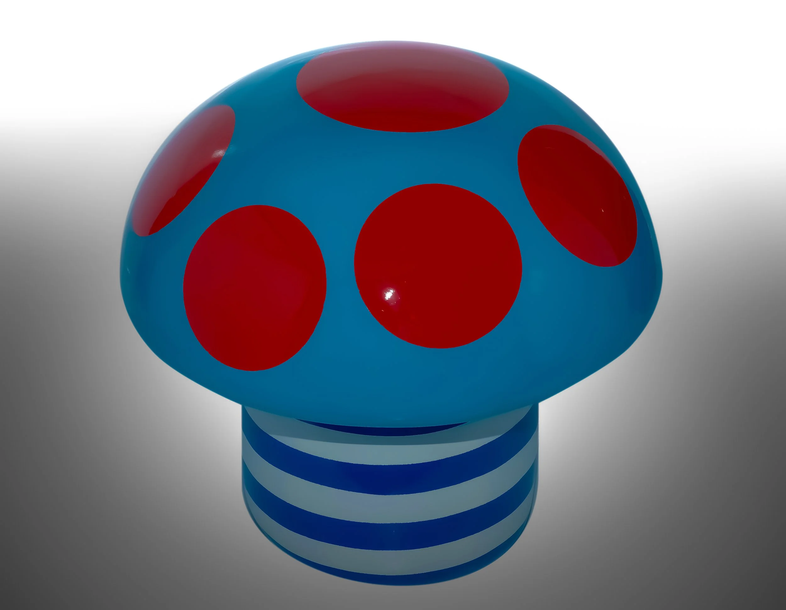Colorful ladybug-shaped toy with a blue body, red spots, and a striped blue and white base.