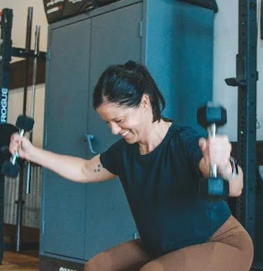 Woman exercising with dumbbells in a gym
