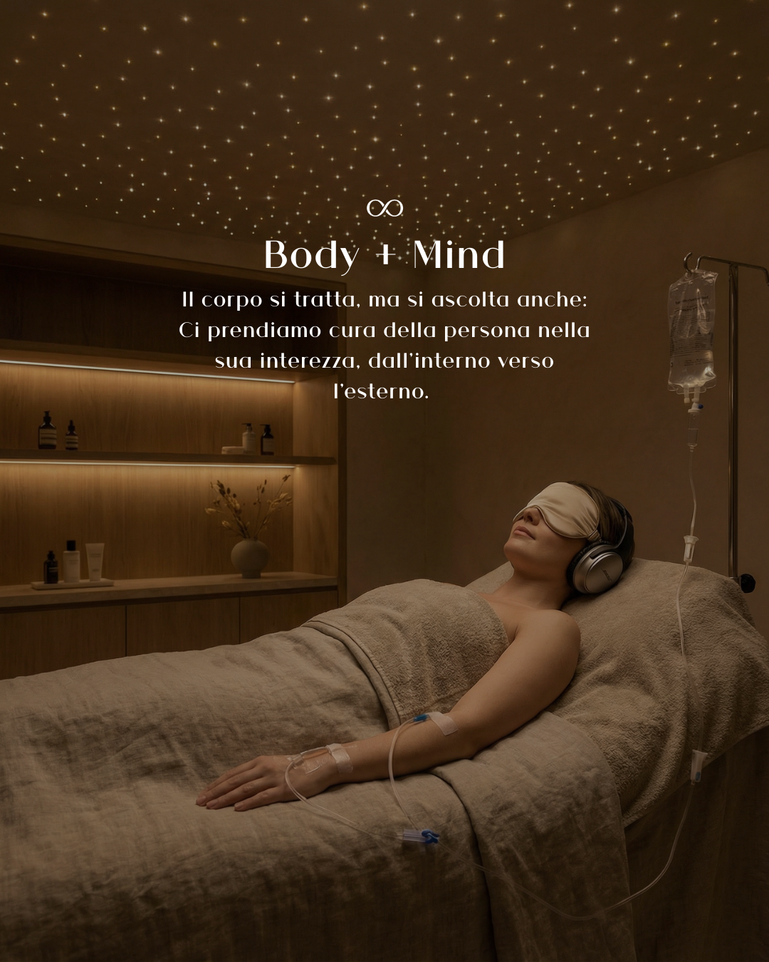 Una donna distesa su un letto, con un occhiolino, mentre ascolta musica con delle cuffie in una stanza con soffitto decorato con luci a forma di stelle e scaffale con prodotti e un vaso con fiori.