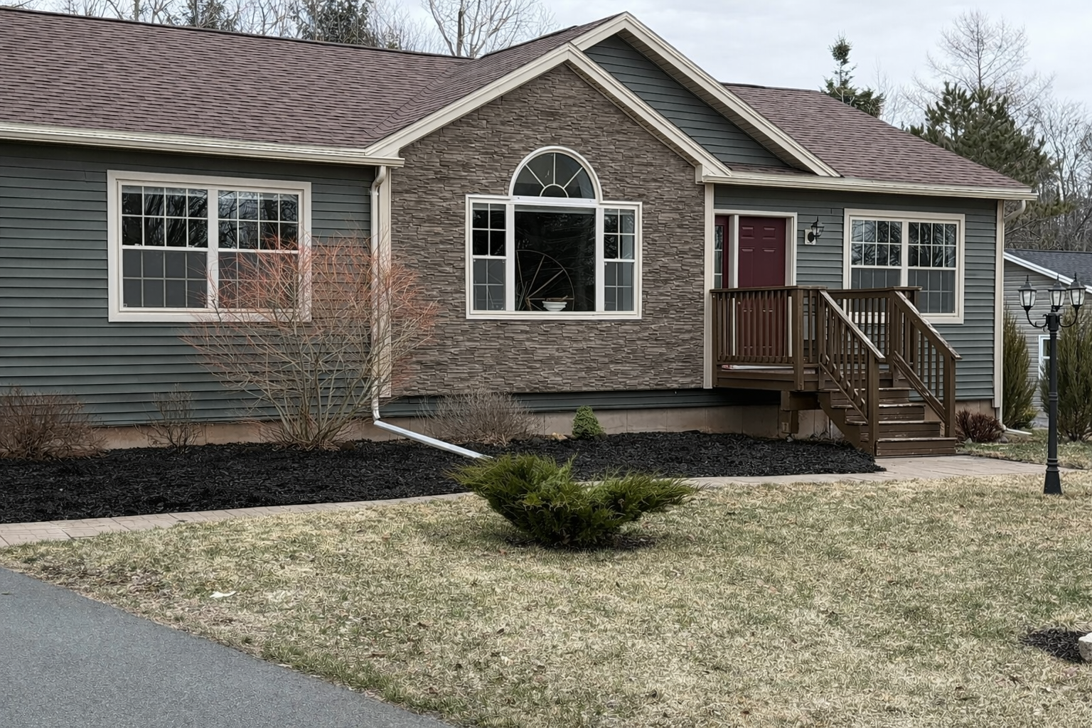 Fresh dark mulch and tidy garden beds along the front of a home.