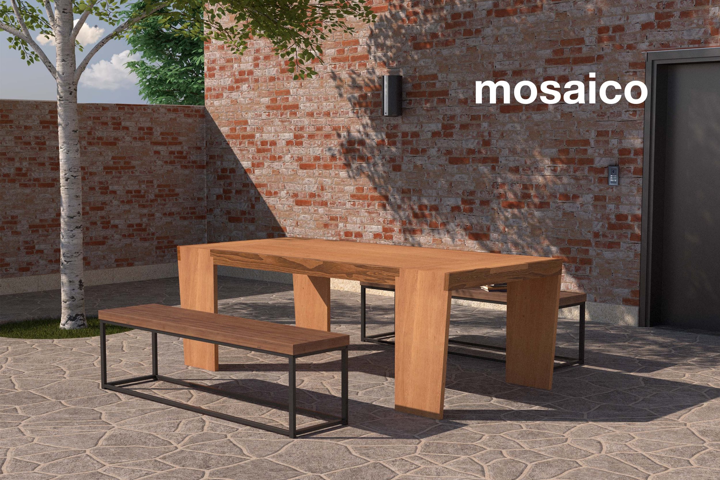 tavolo per esterni al centro di un cortile rivestito di mattoni e affiancato da due panche in metallo e legno
