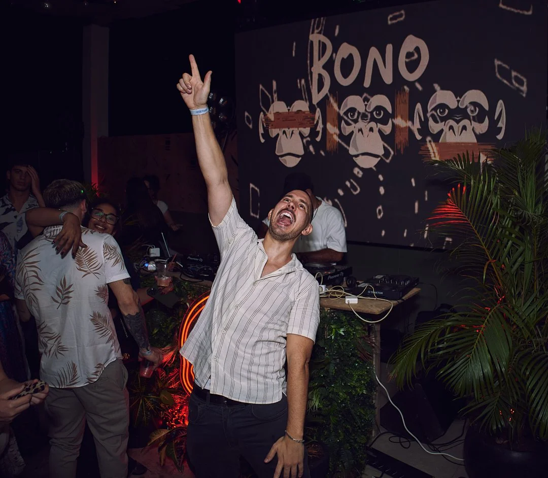 A man pointing up and screaming of joy at a party