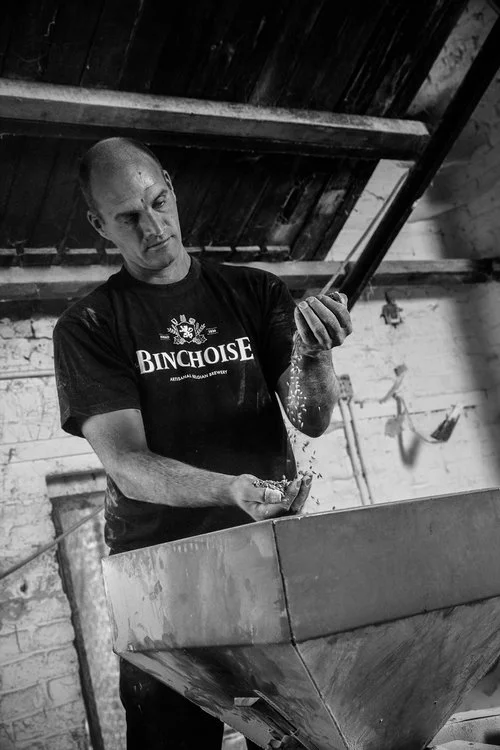 A brewer checking the malt he uses for his beer. The photo is black and white in the production unit of a brewery