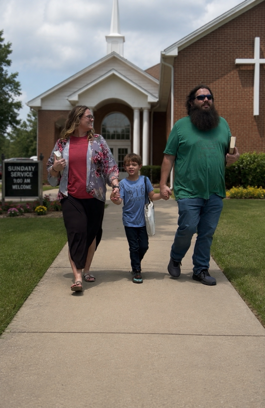 A family walking hand in hand in front of a church on a cloudy day, with a sign indicating Sunday service at 9:00 am.