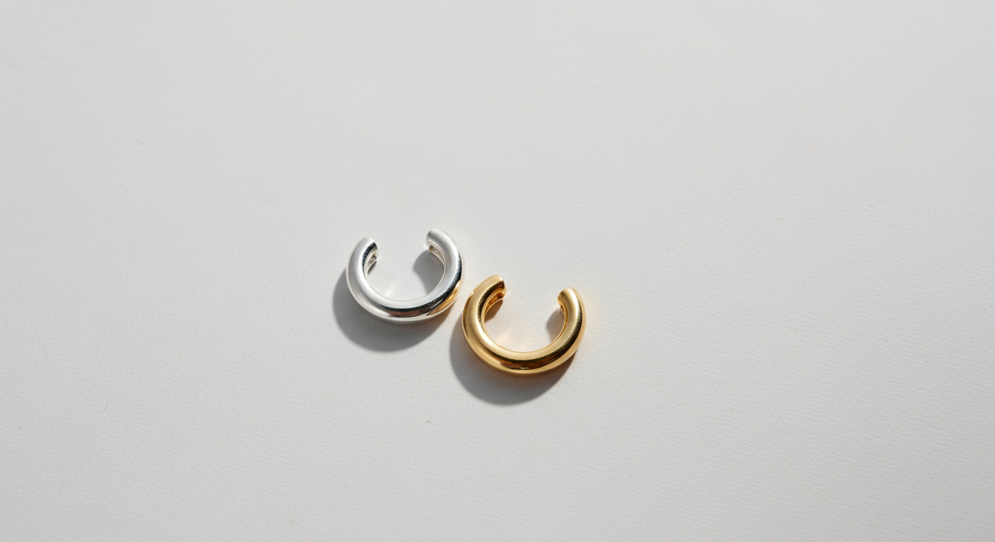 Silver and gold hoop earrings on a plain white surface