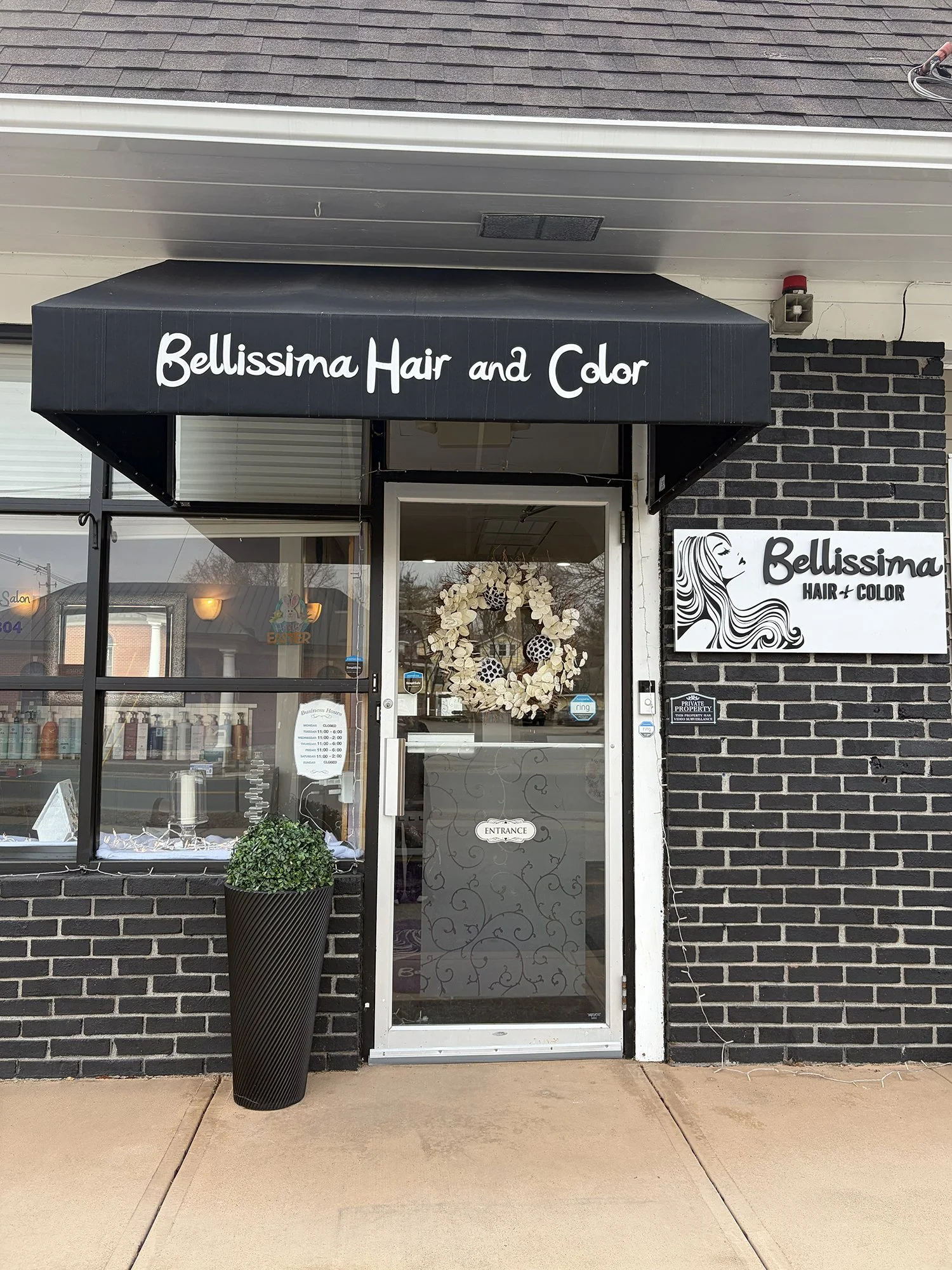 Exterior of Bellissima Salon, showing door and awning at entrance.