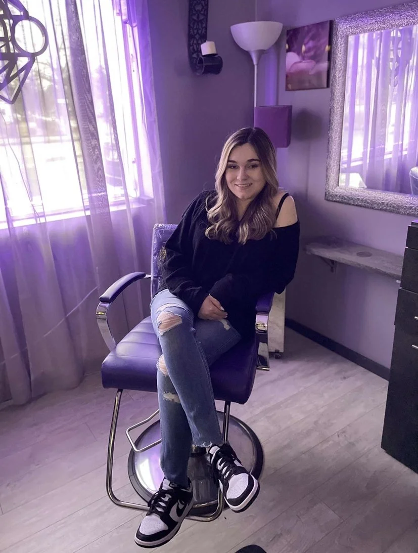 Katie Jones, a stylist at Bellissima Salon, is shown in a salon chair.