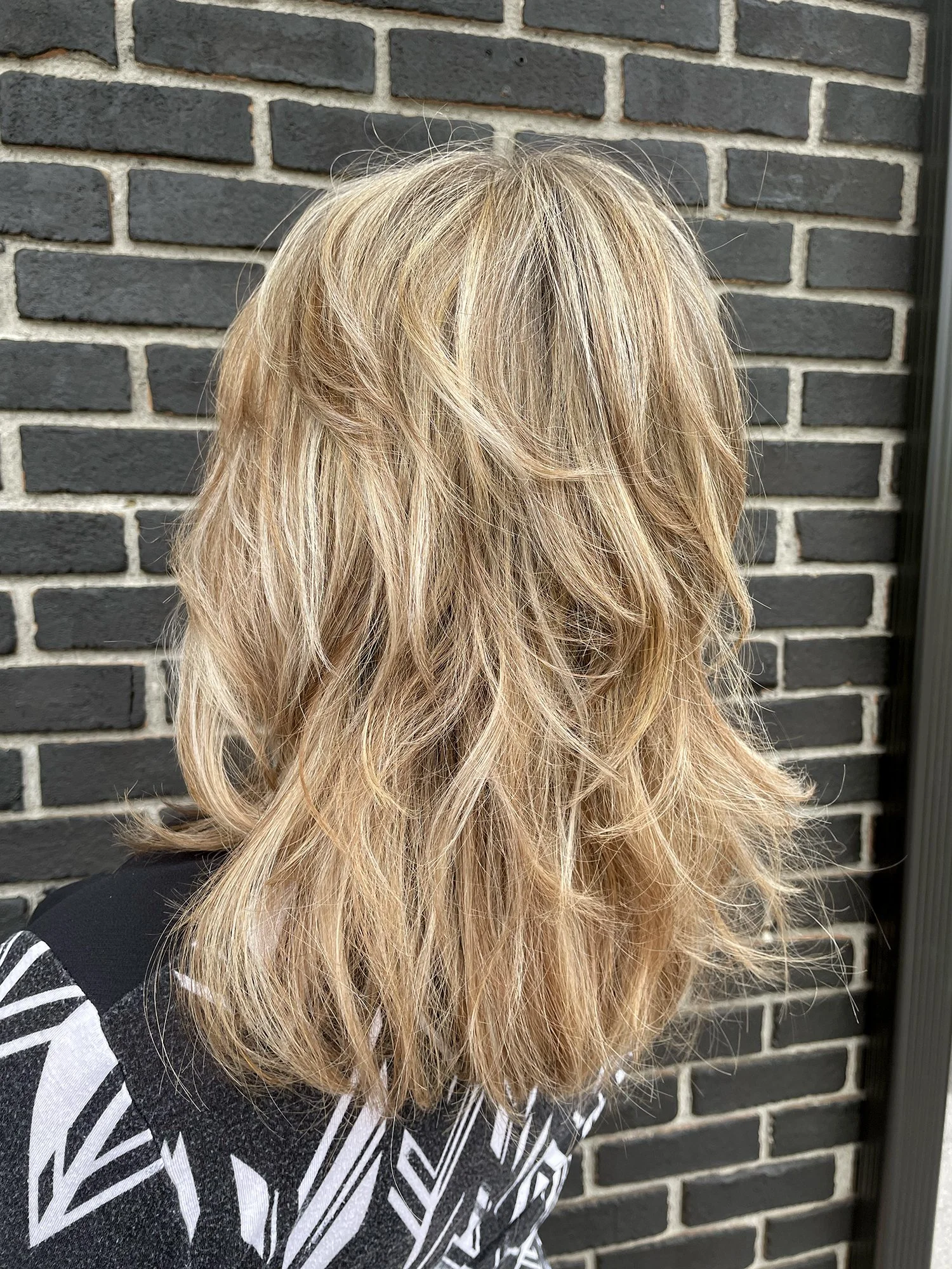 Blonde layered mid-length hairstyle.