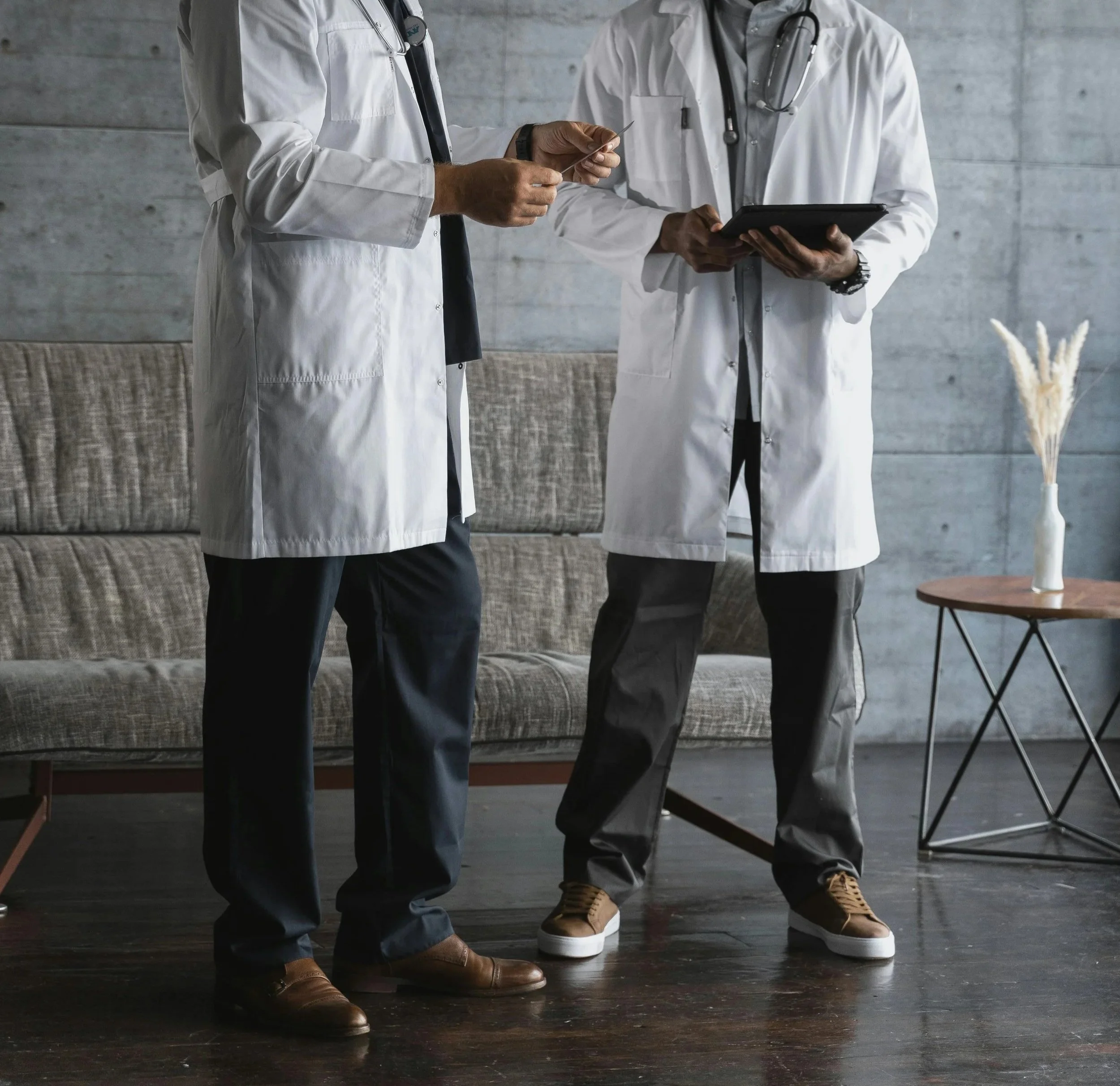 Medical professionals in white coats having a discussion indoors.