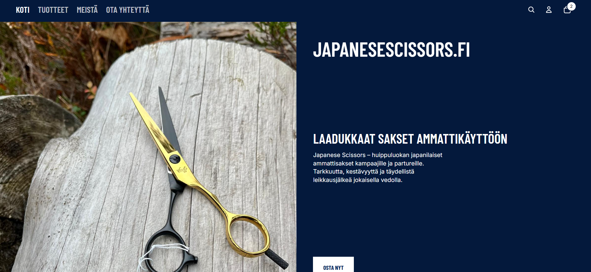 A pair of professional Japanese scissors with black and gold handles resting on a weathered wooden surface outdoors.