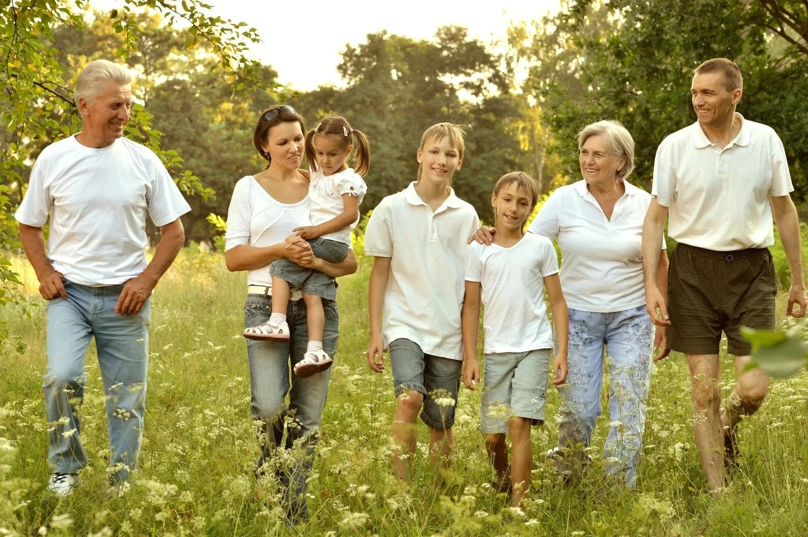 Family walking together in a park on a sunny day.