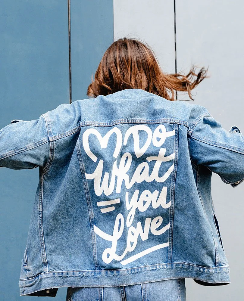 Amy Jones wearing a denim jacket with the message 'Do what you love' written in white on the back.