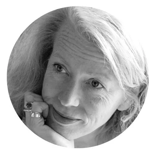 Schwarz-weiß Porträt einer Frau mit lockigem Haar, die nachdenklich aussieht.