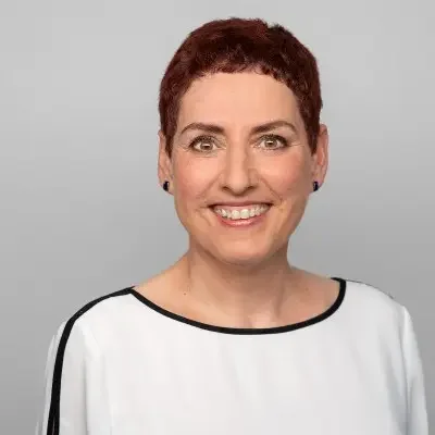 Eine Frau mit kurzen dunklen Haaren und einem weissem T-Shirt.
