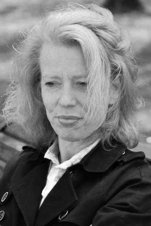 Schwarz-weiß-Foto einer Frau mit kurzem, schulterlangen Haar, die nachdenklich schaut.