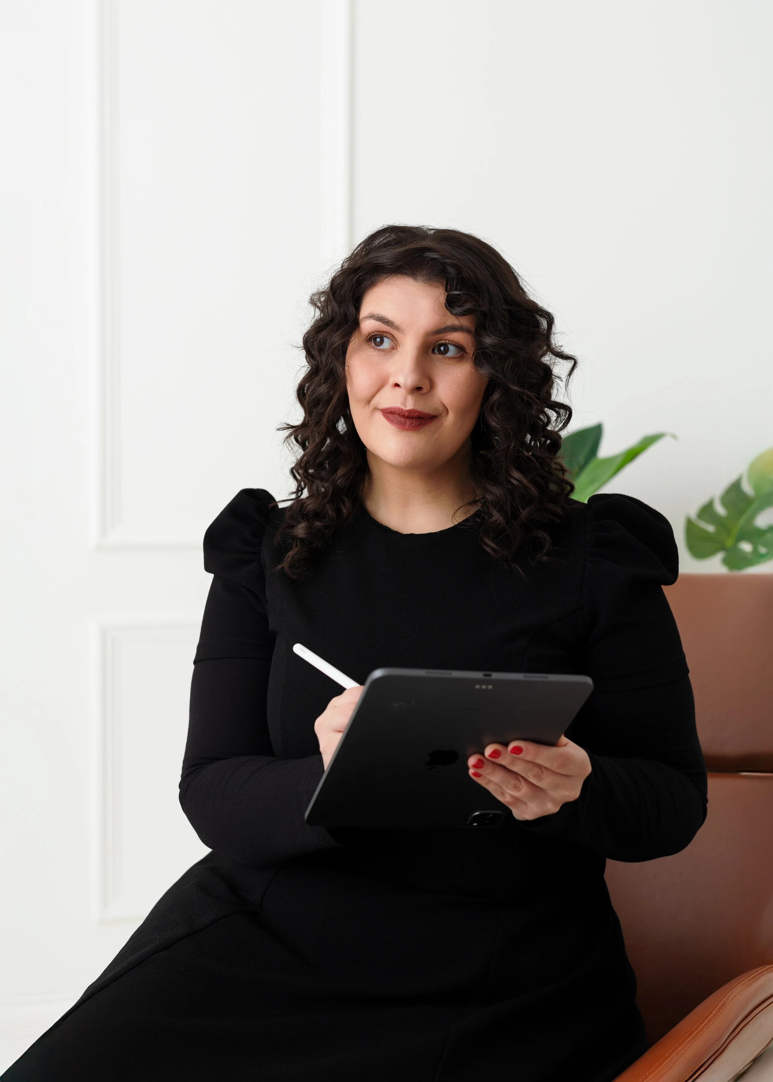 Chloë Forbes-Kindlen, founder of BusinessOPS, using a tablet to design Notion workspace systems for business operations.