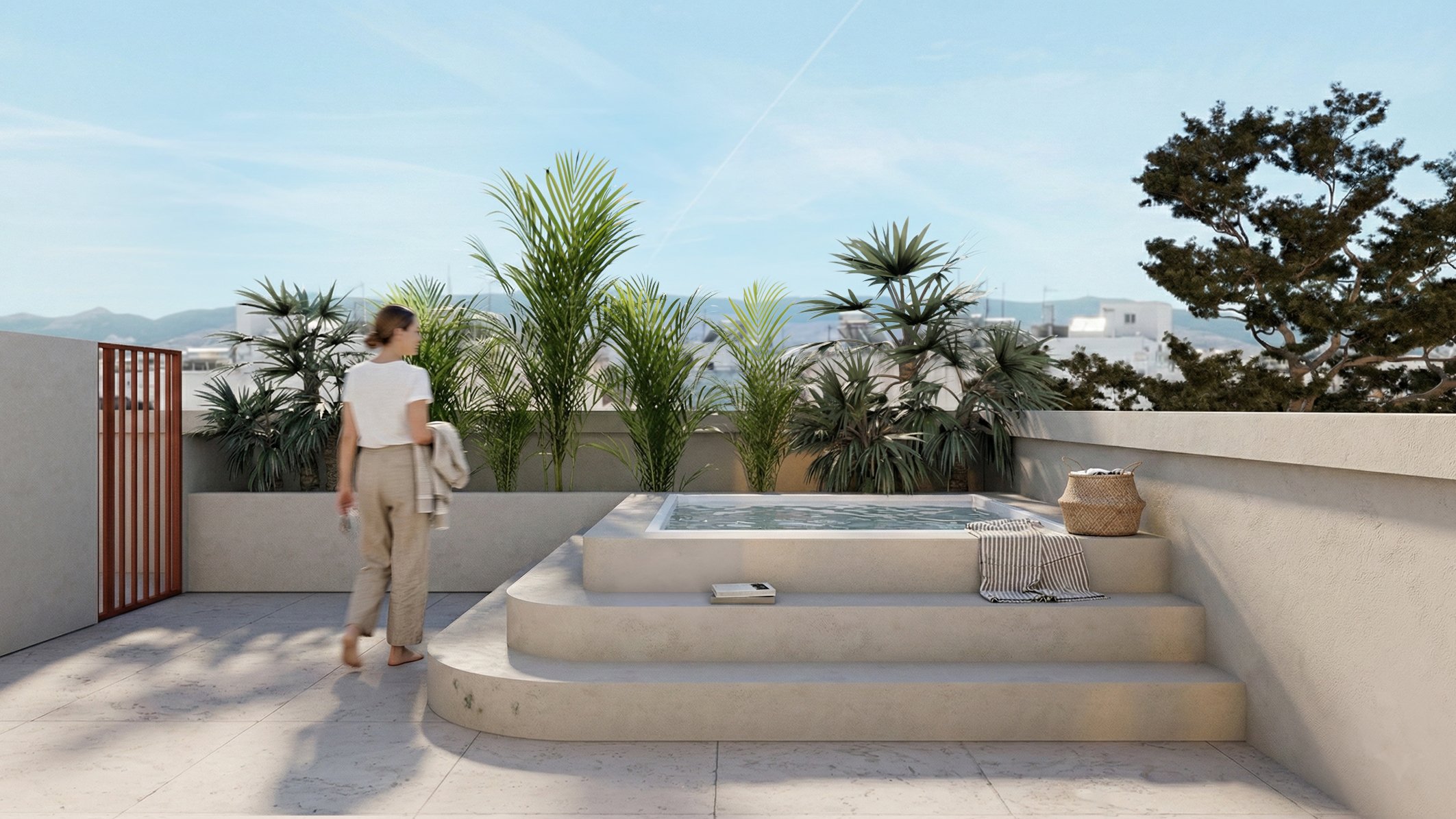 A woman walking past a rooftop hot tub with stairs, surrounded by potted plants and with a cityscape and mountains in the background.