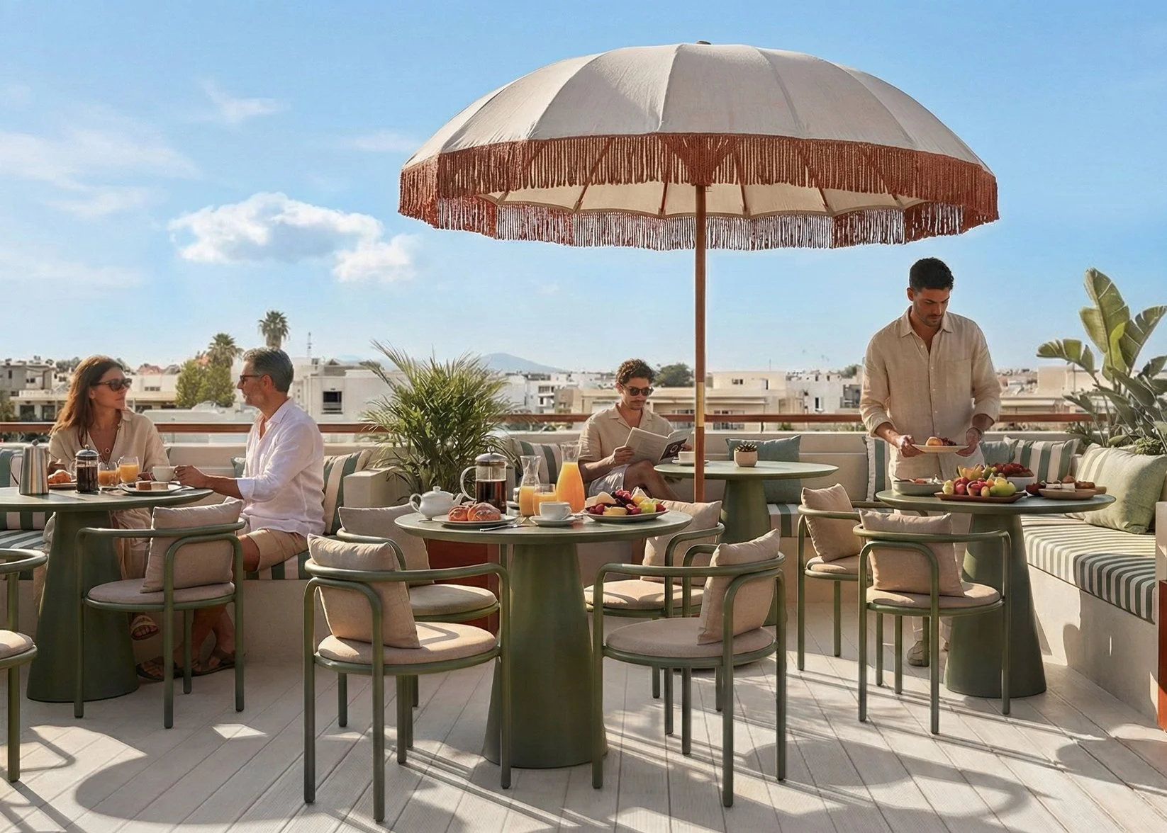 People enjoying breakfast on a sunny rooftop terrace with tables, chairs, and a large umbrella, cityscape in background.