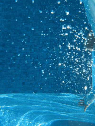 Young swimming student during a dive to pick up a toy from the bottom of the pool.