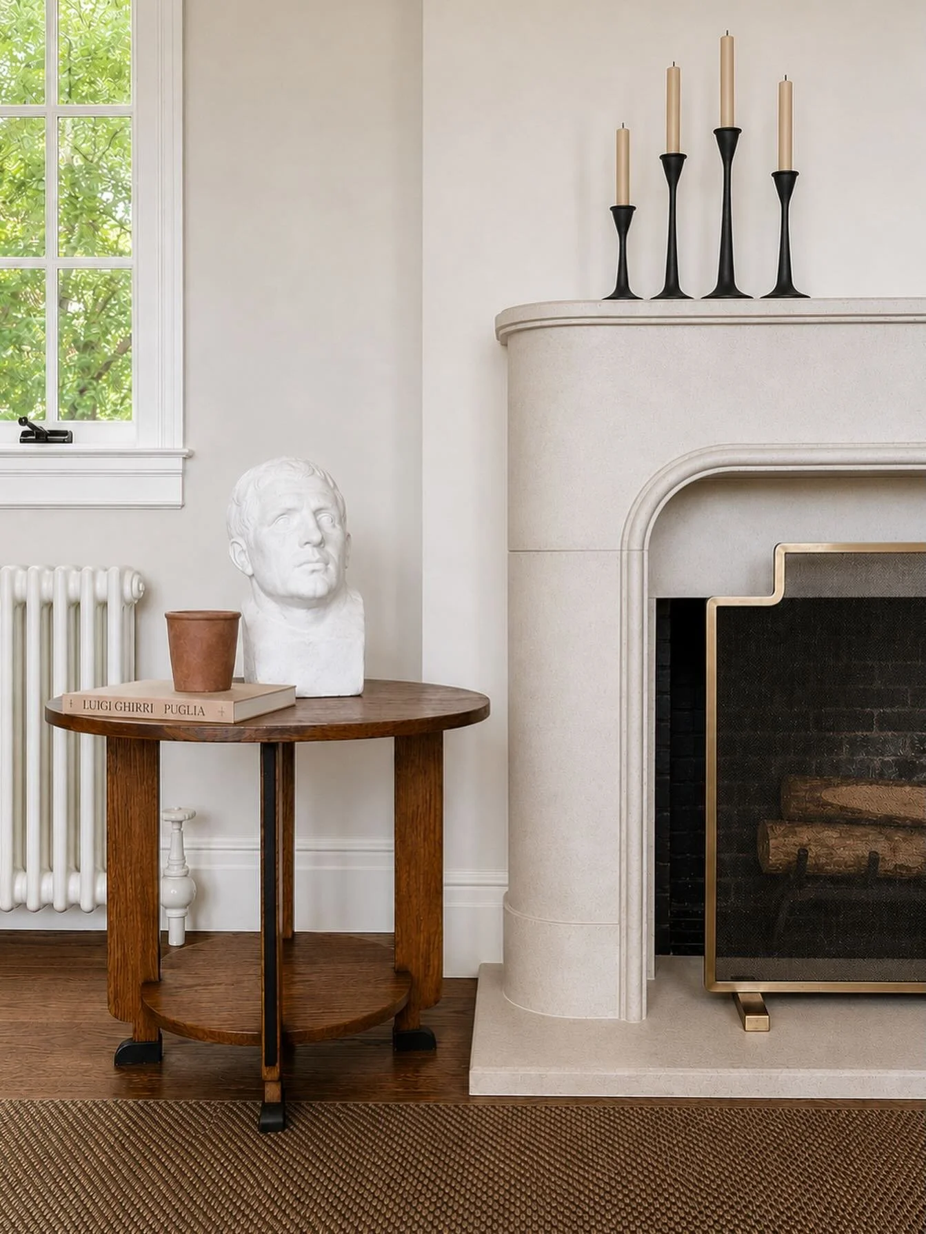 A soft moment at Camp Comfort Road. We removed the existing wood mantle and replaced it with this sculptural limestone beauty atop a Roman clay wall treatment. Layered in a sisal area rug, a French art deco side table, and an original sculpture (by a
