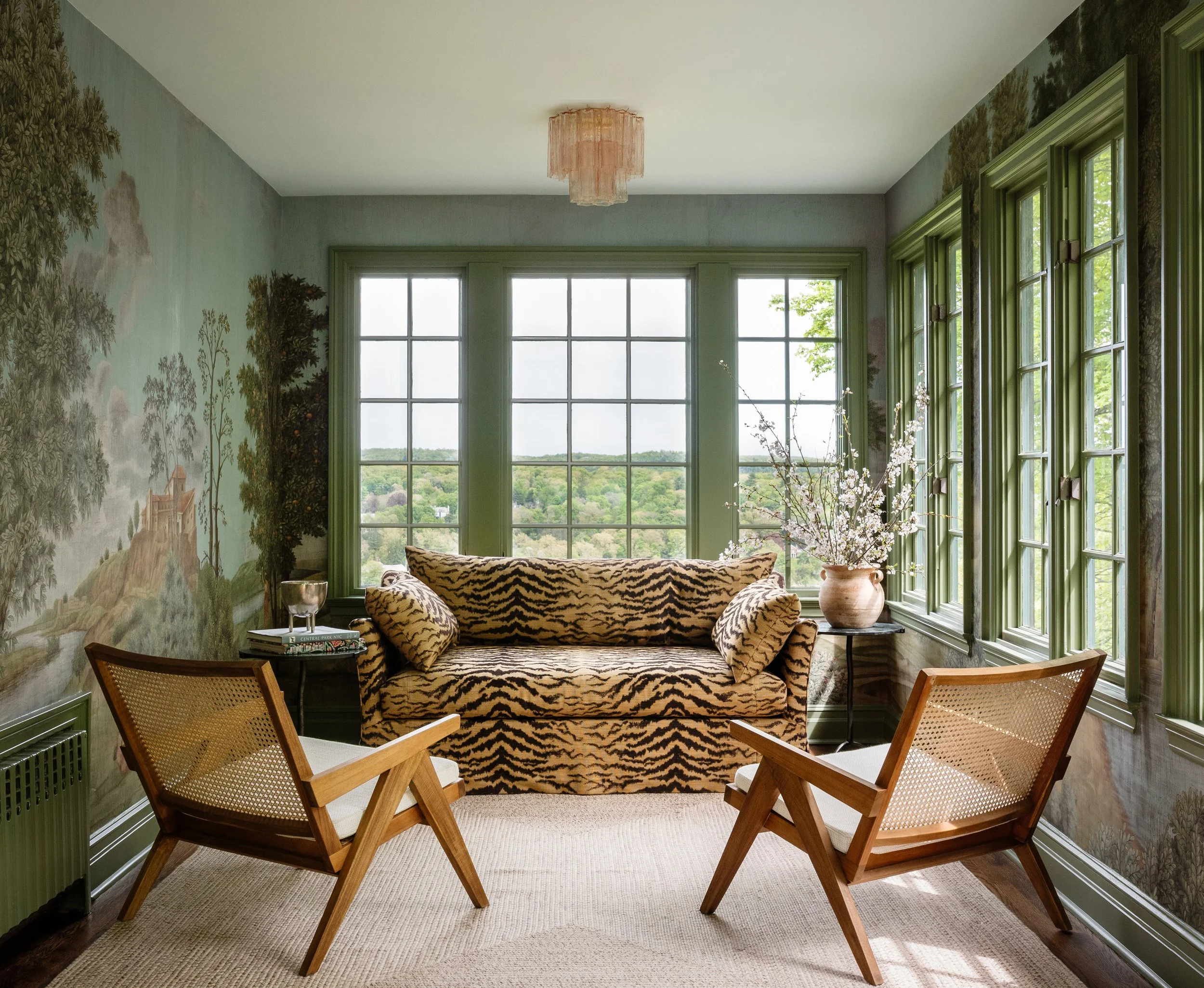 sunroom with tiger print sofa and wall mural upstate new york