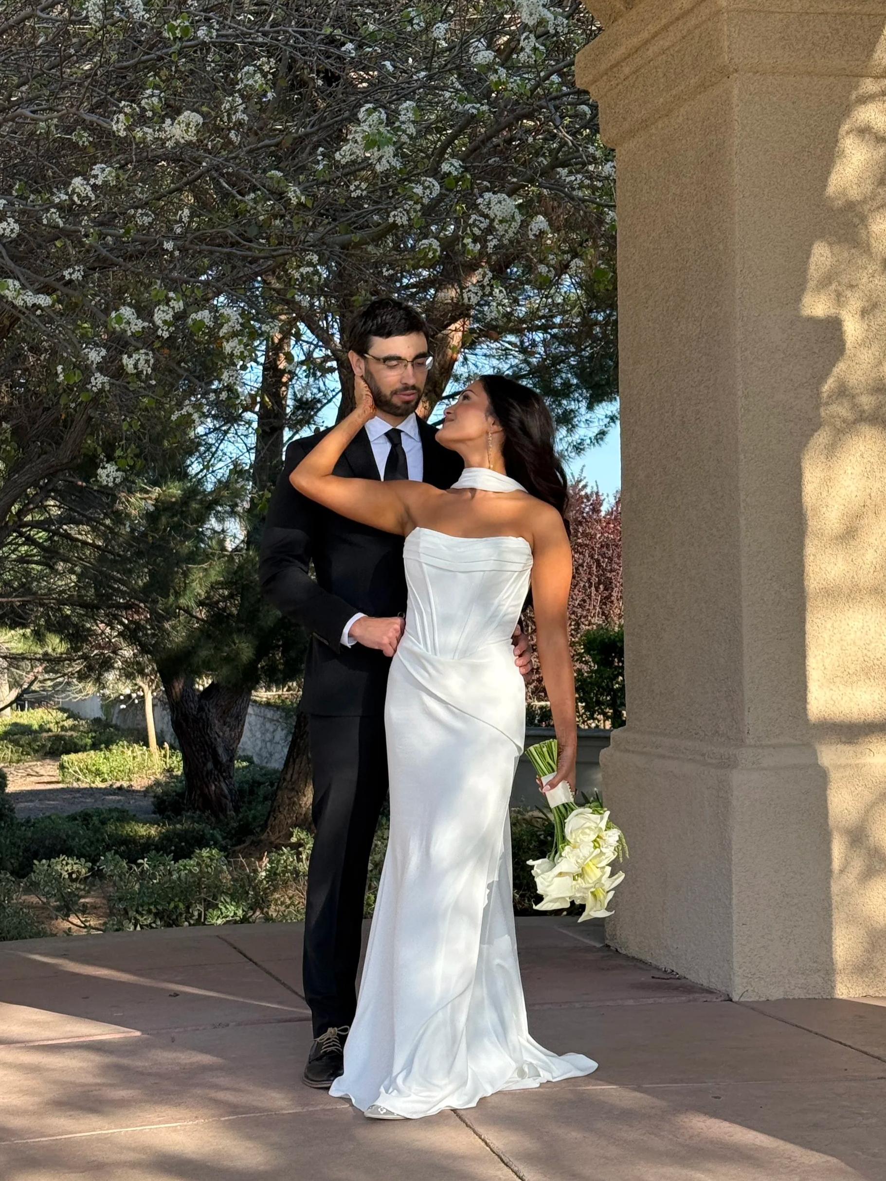 Laurie’s customers, Mariana and Carmen holding hands on a green lawn on their wedding day.