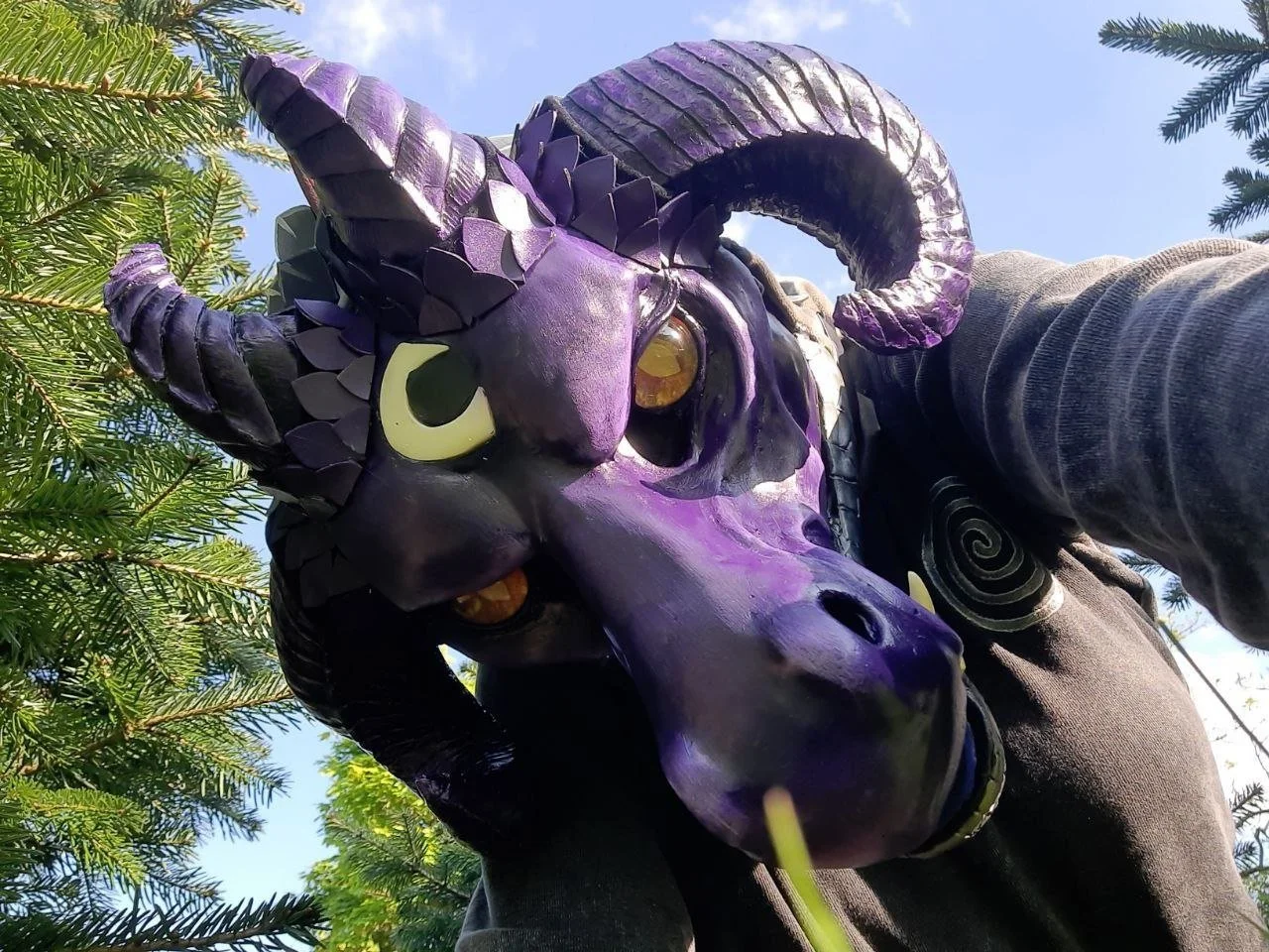 Purple dragon fursuit head with white markings and four horns.