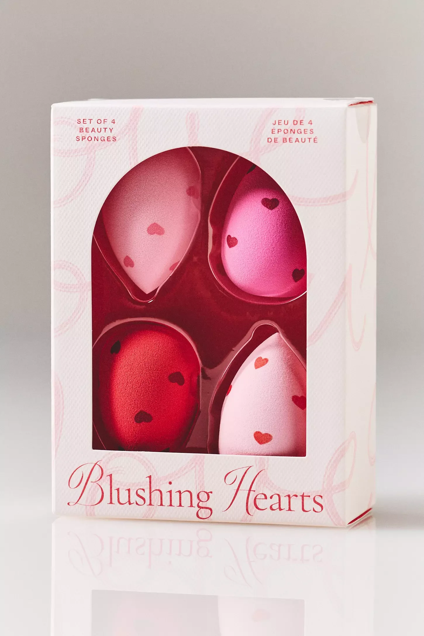 Box of jewelry blushing hearts sponges, showing four pink and red heart-shaped sponges with small heart designs on them
