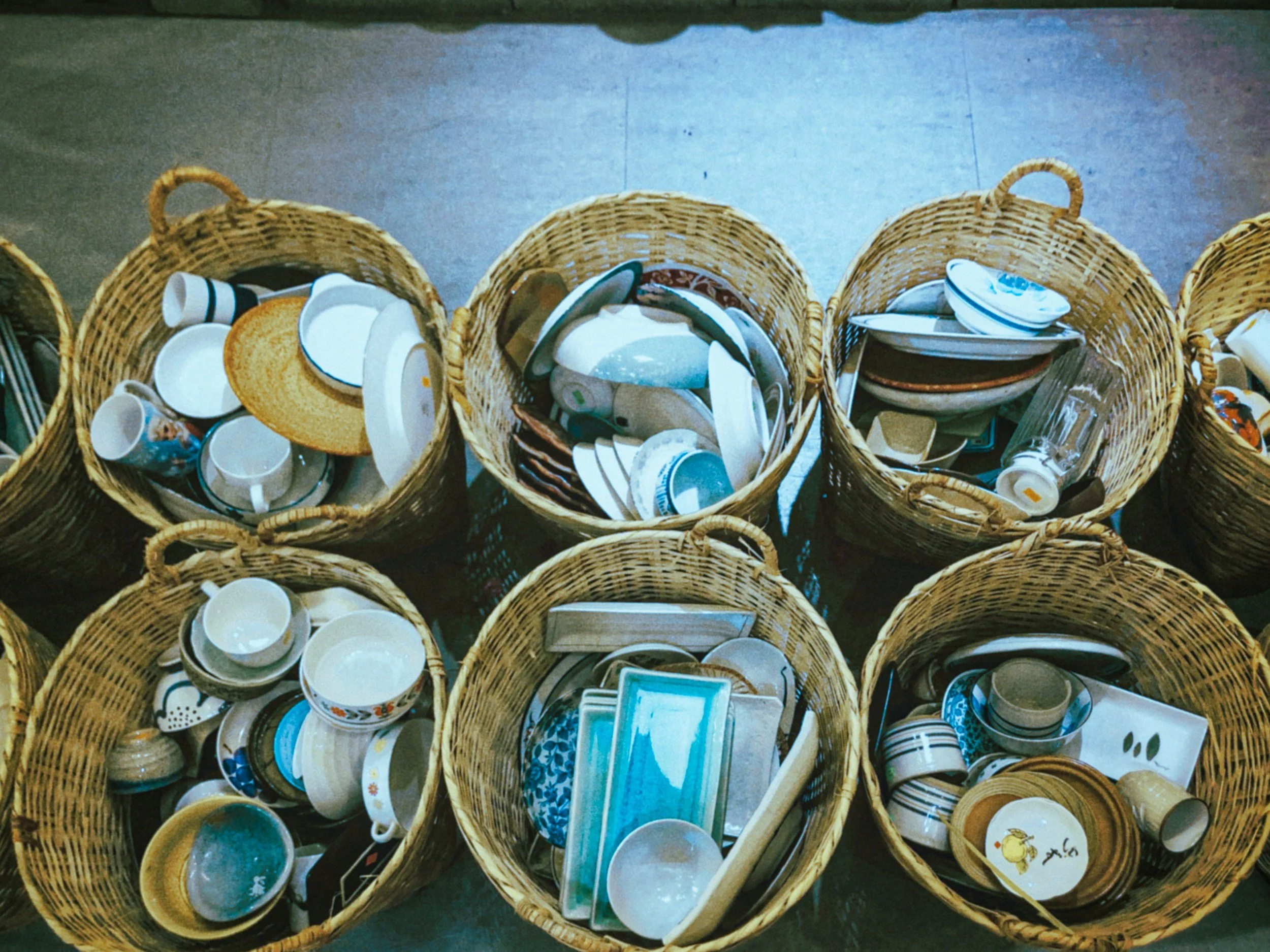 several wicker bins full of various dishware