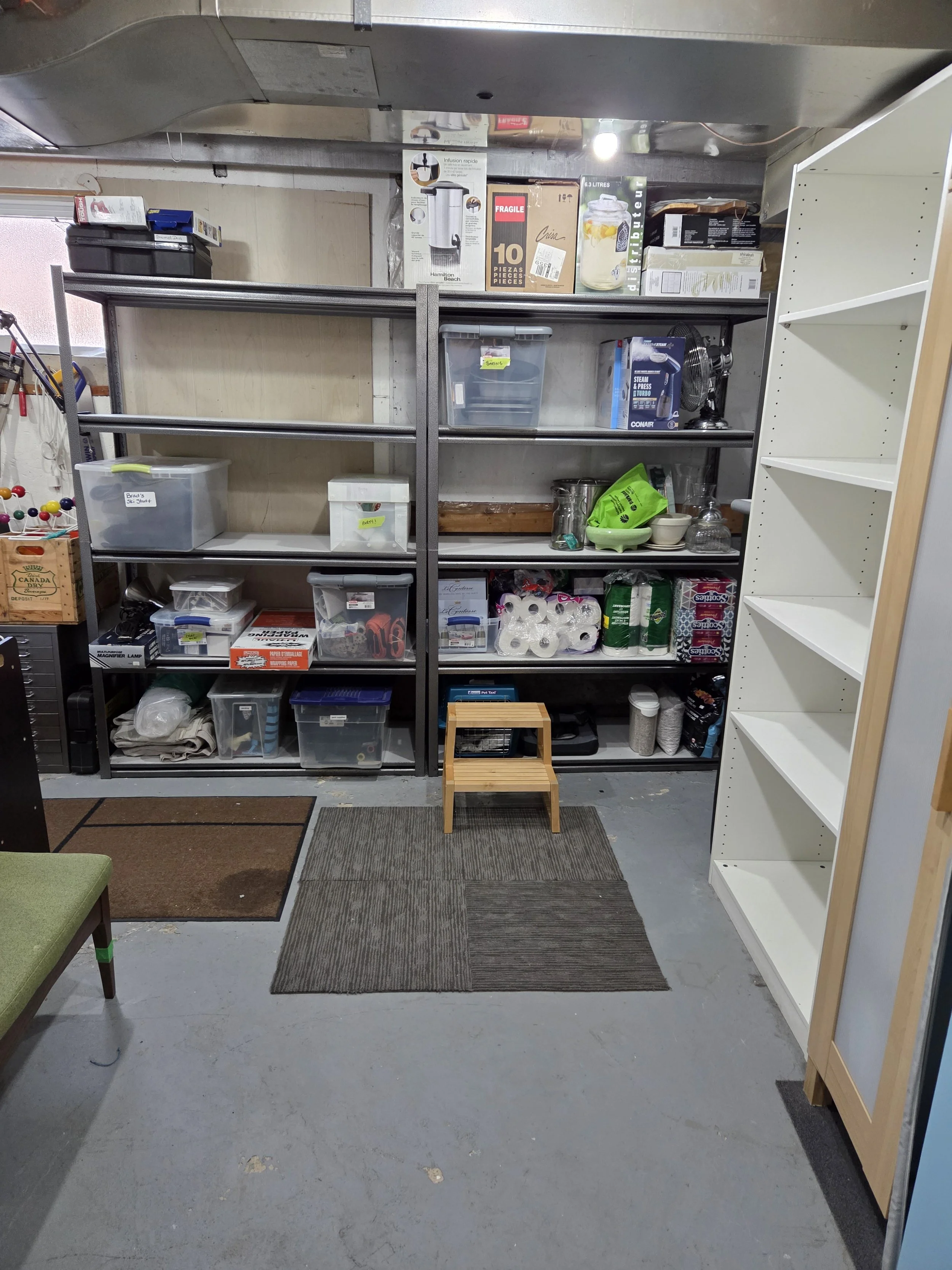 Furnace room after Step In Session, with empty shelves and organized labeled bins and clear walking path.