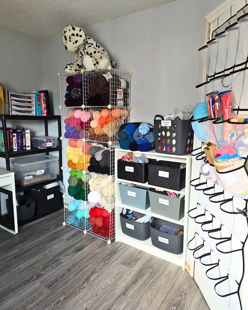Craft room with visible yarn, projects, and supplies in labeled bins and is well organized.