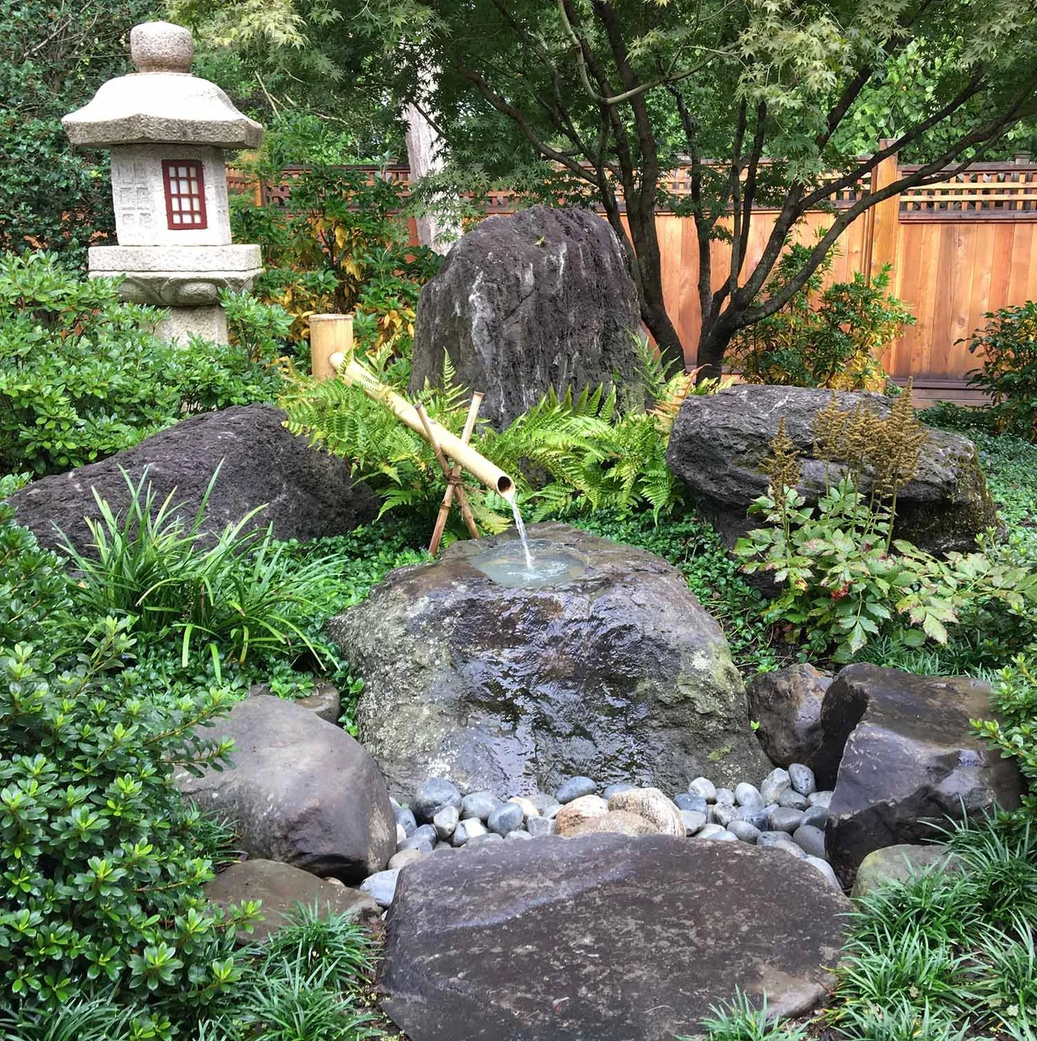 Traditional Japanese water basin arrangement with Stone lantern and bamboo water spout