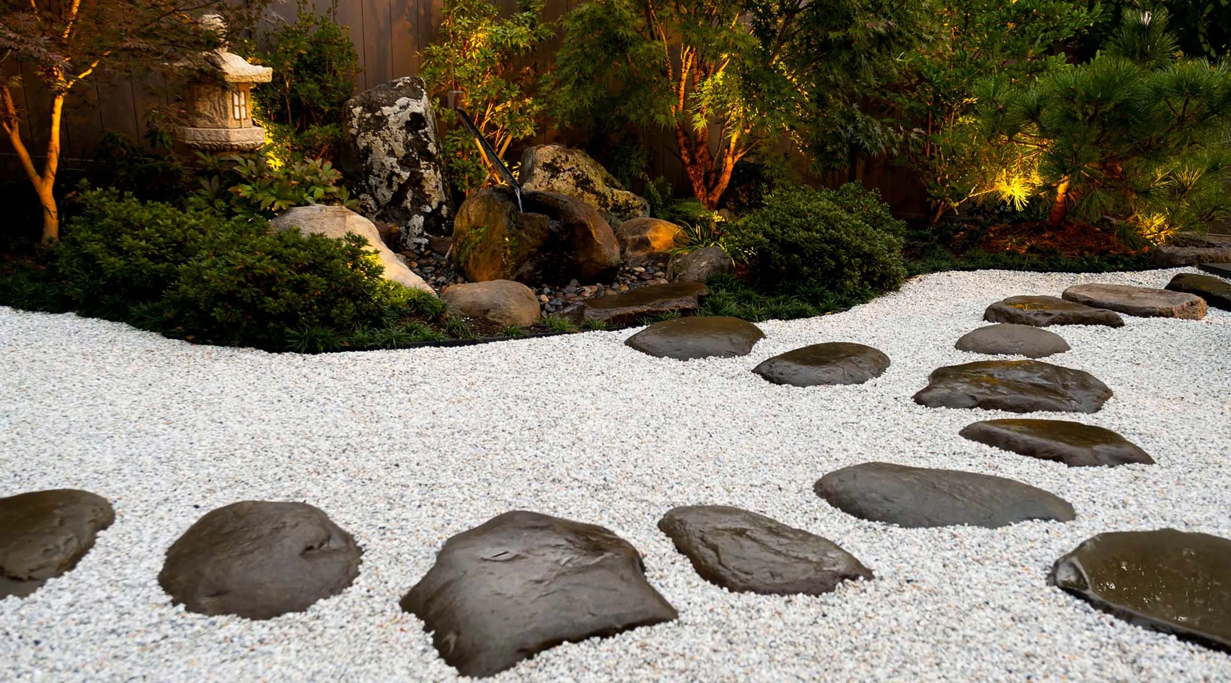 Japanese garden with Tea garden style water basin arrangement including natural boulder basin and stone lantern and stepping stones