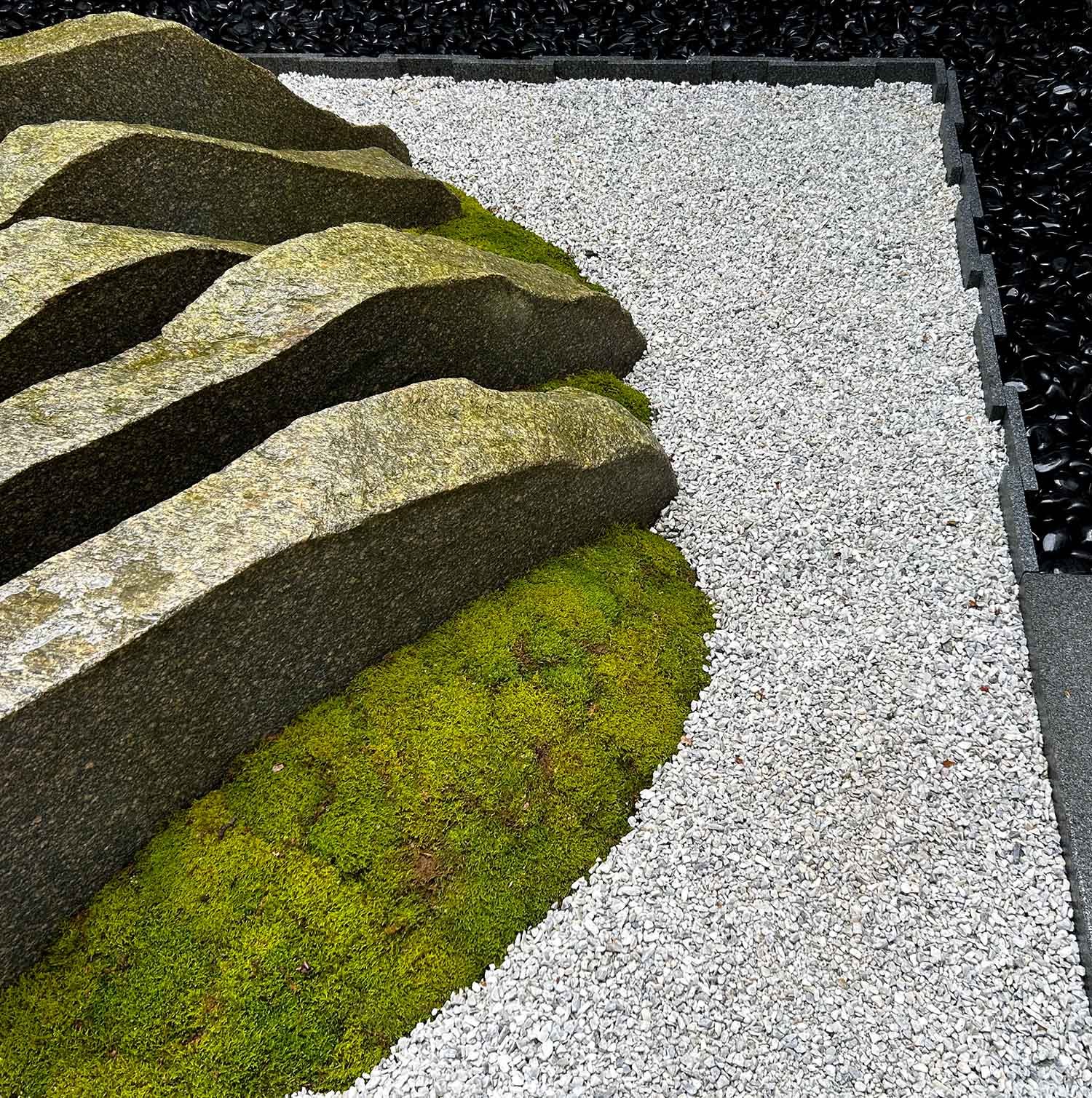 Modern Japanese courtyard atrium garden with cut granite slabs and moss