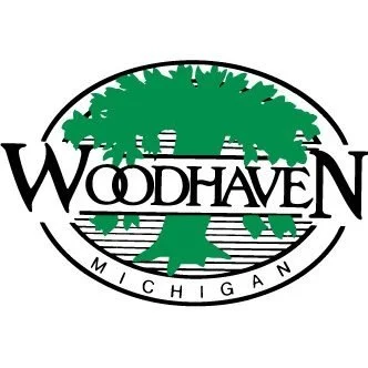 Logo for Woodhaven, Michigan, featuring a large green tree with black and white text.