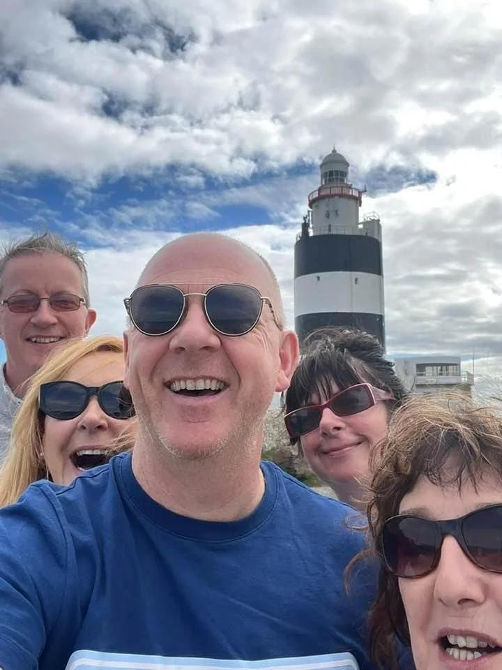 Breda and friends pose in front of a light house.