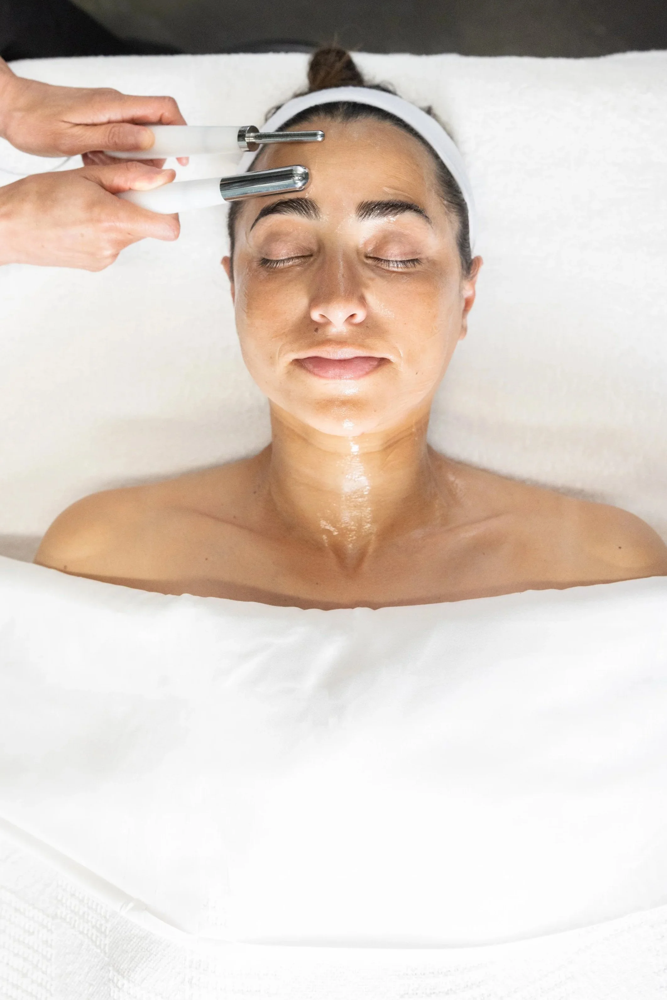 Esthetician performing a microcurrent facial treatment at Wax n' Peels in Monrovia, CA.
