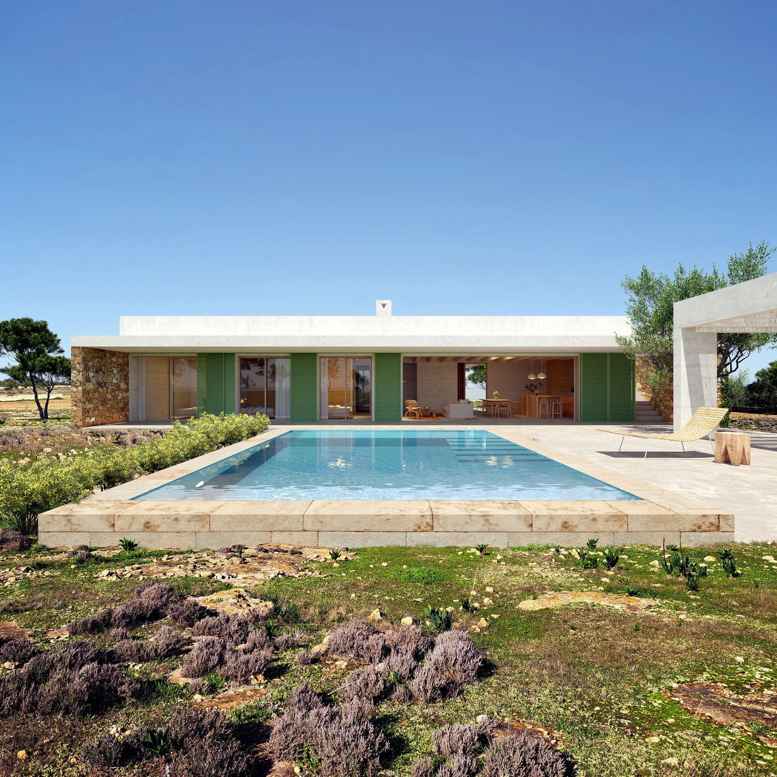 Modern house with white walls, large glass doors, and green shutters, with a swimming pool in front surrounded by a stone patio and outdoor furniture, set against a clear blue sky and natural landscape.