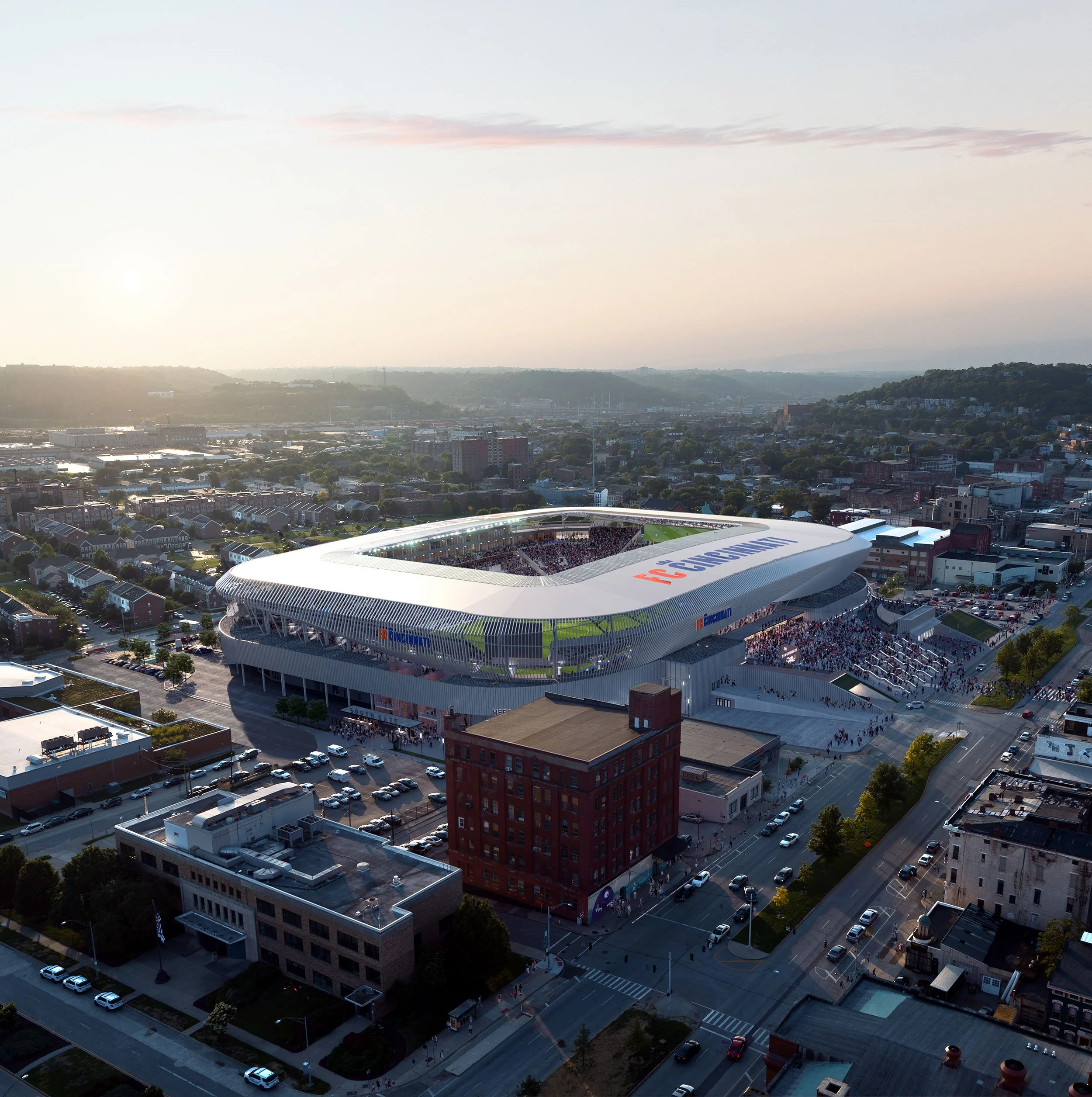 Aerial view of Nissan Stadium in Nashville, Tennessee, filled with spectators for a football game, with surrounding buildings and cityscape at sunset.