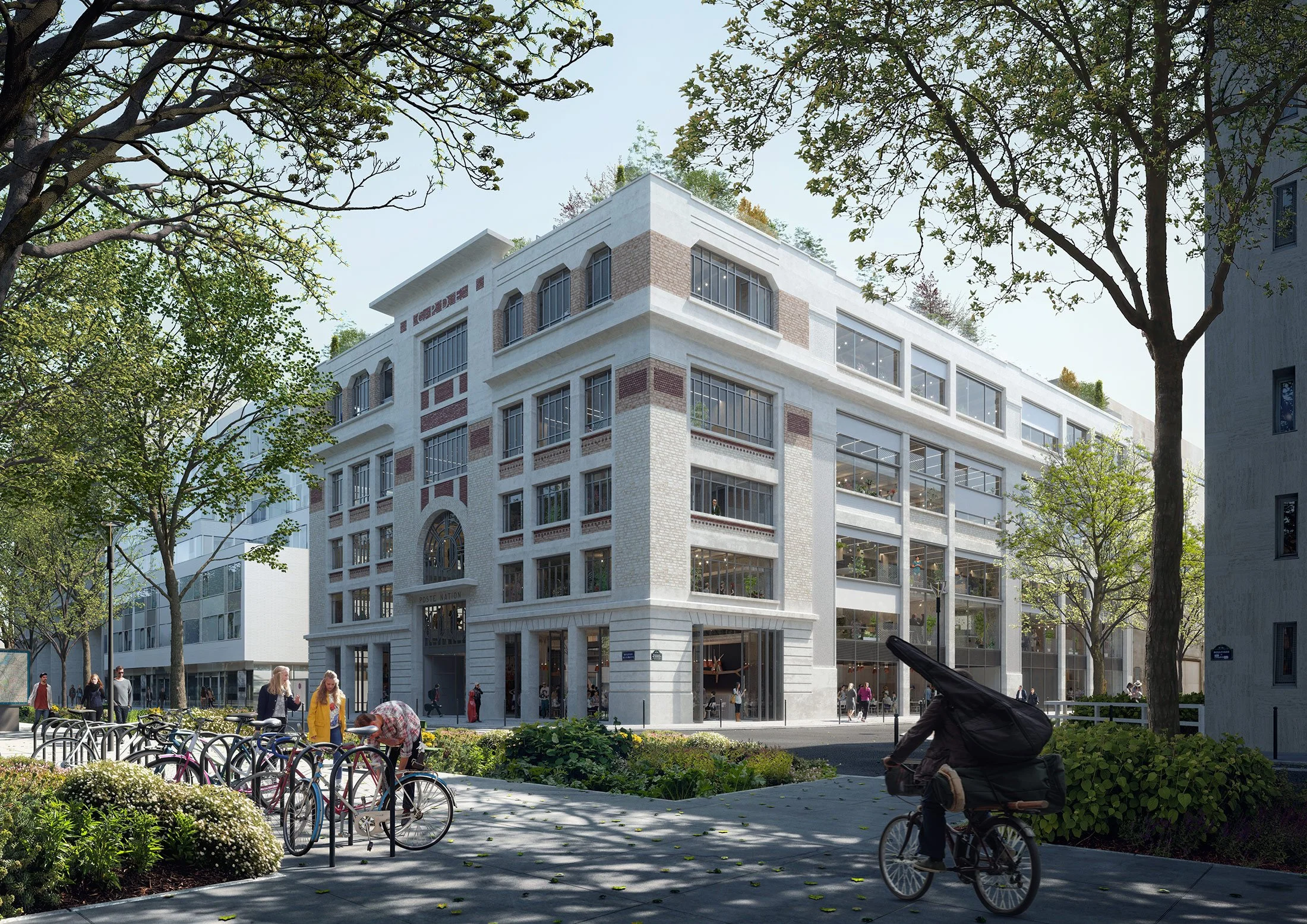 A modern, multi-story building with large glass windows on a city street, surrounded by trees and greenery. People are walking and biking on the sidewalk in front of the building.