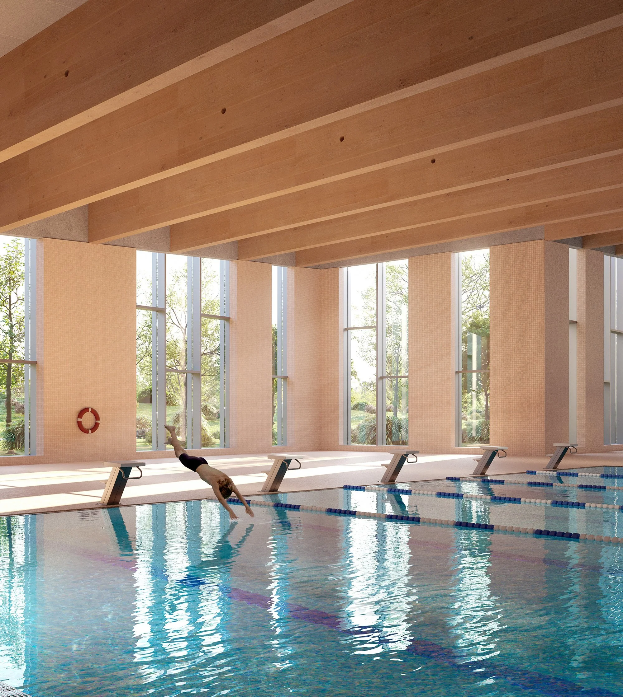 Indoor swimming pool with a swimmer diving into the water, large windows allowing natural light, wooden ceiling beams, and beige walls.