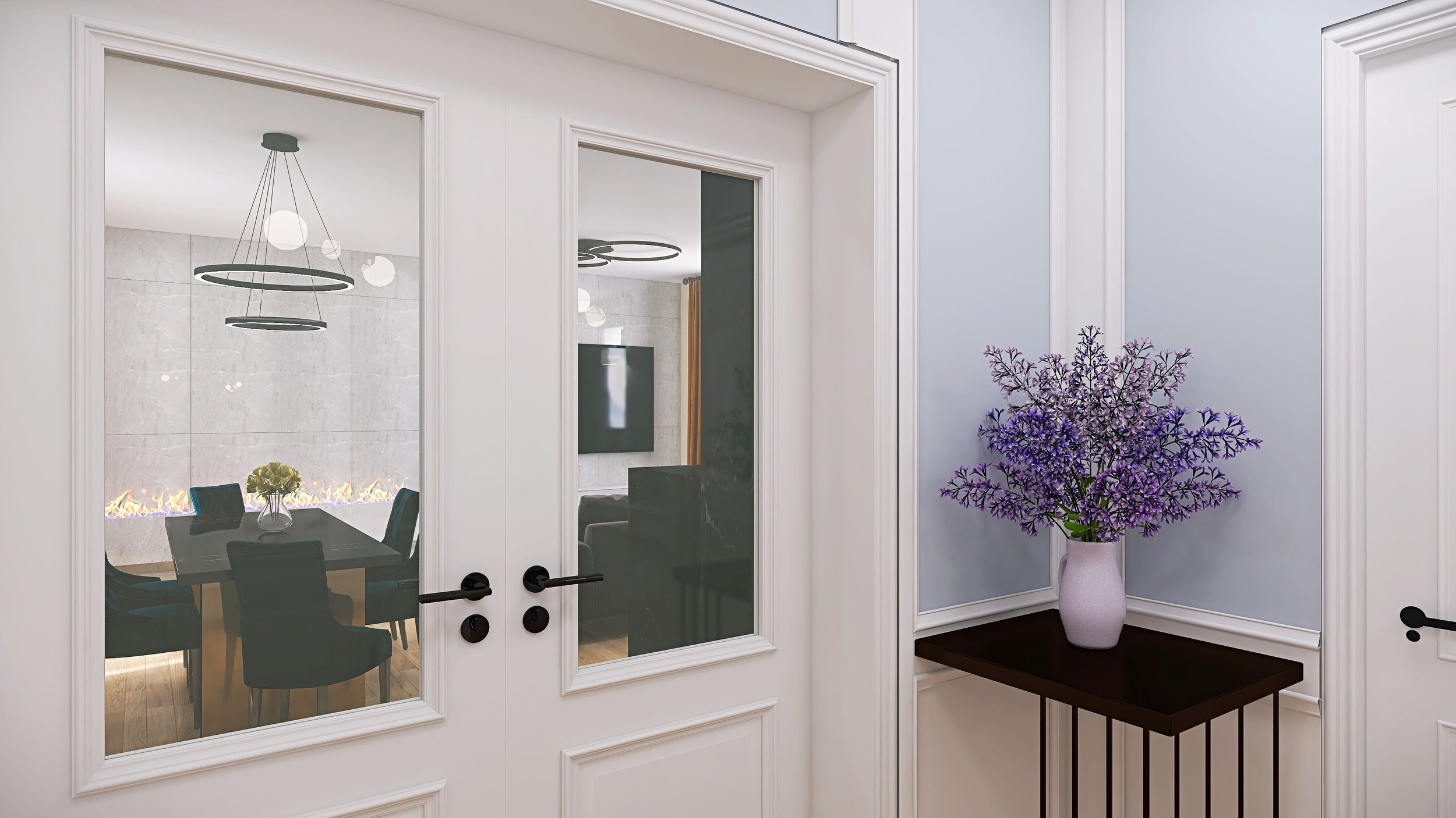 A white wall with a small dark wood table holding a vase of purple flowers, a door with glass panels revealing a dining area with a black table and chairs, a fireplace, and modern lighting fixtures.
