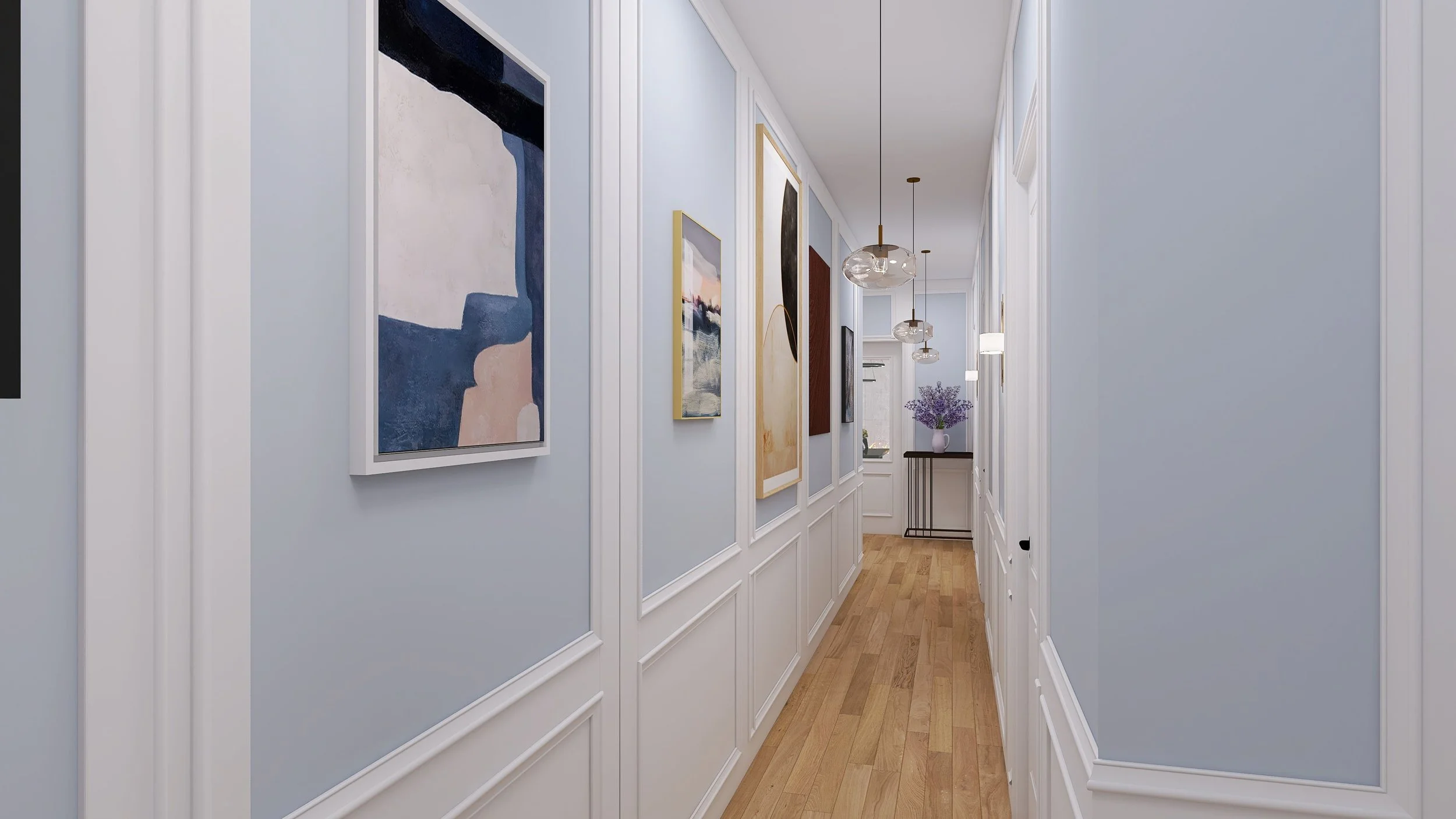 A hallway with light blue walls, white wainscoting, hardwood floors, and modern hanging light fixtures. Artwork decorates the walls, and a small table with purple flowers is at the end of the hallway.