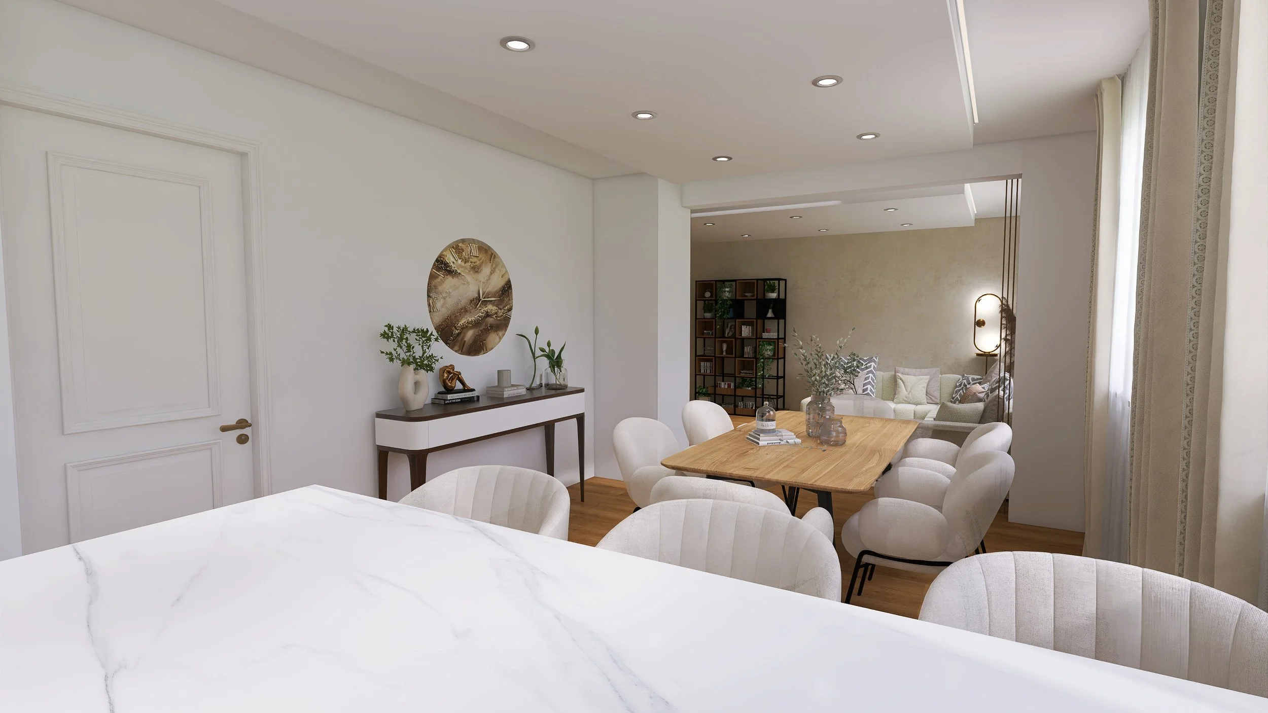 Modern dining and living room area with white walls, wooden flooring, and natural light from windows; includes a dining table with chairs, a sideboard with decor, and a cozy seating area with a bookshelf.